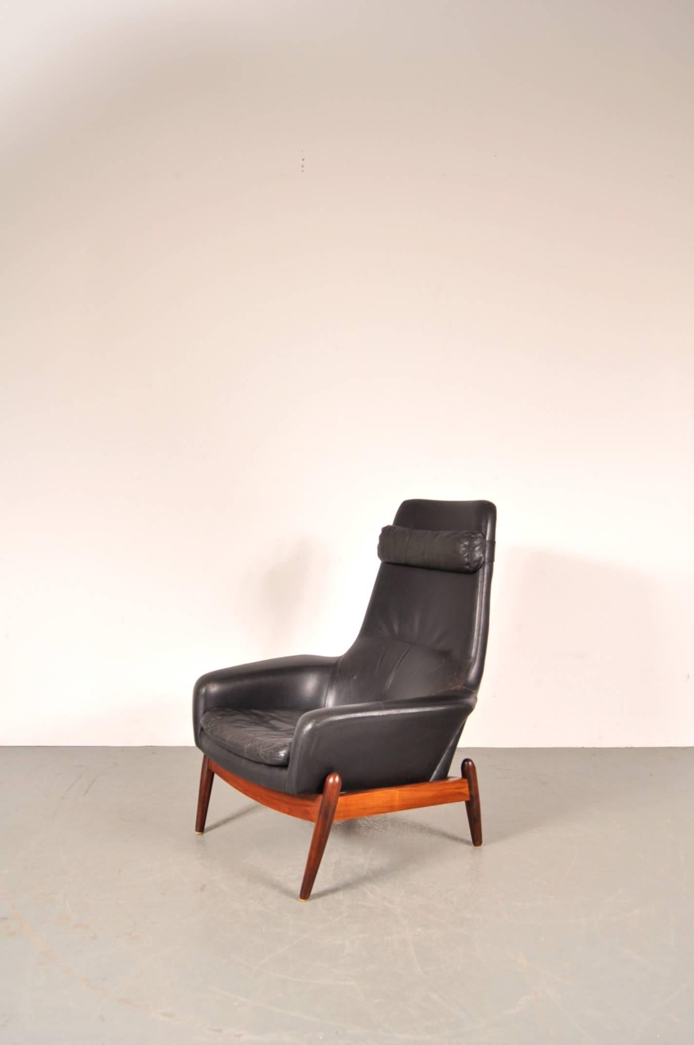 Stunning easy chair designed by Ib Kofod-Larsen, manufactured by Bovenkamp in the Netherlands, circa 1960.

This wonderful piece is upholstered in the highest quality black leather on a beautiful rosewood base. The armrests are also upholstered in