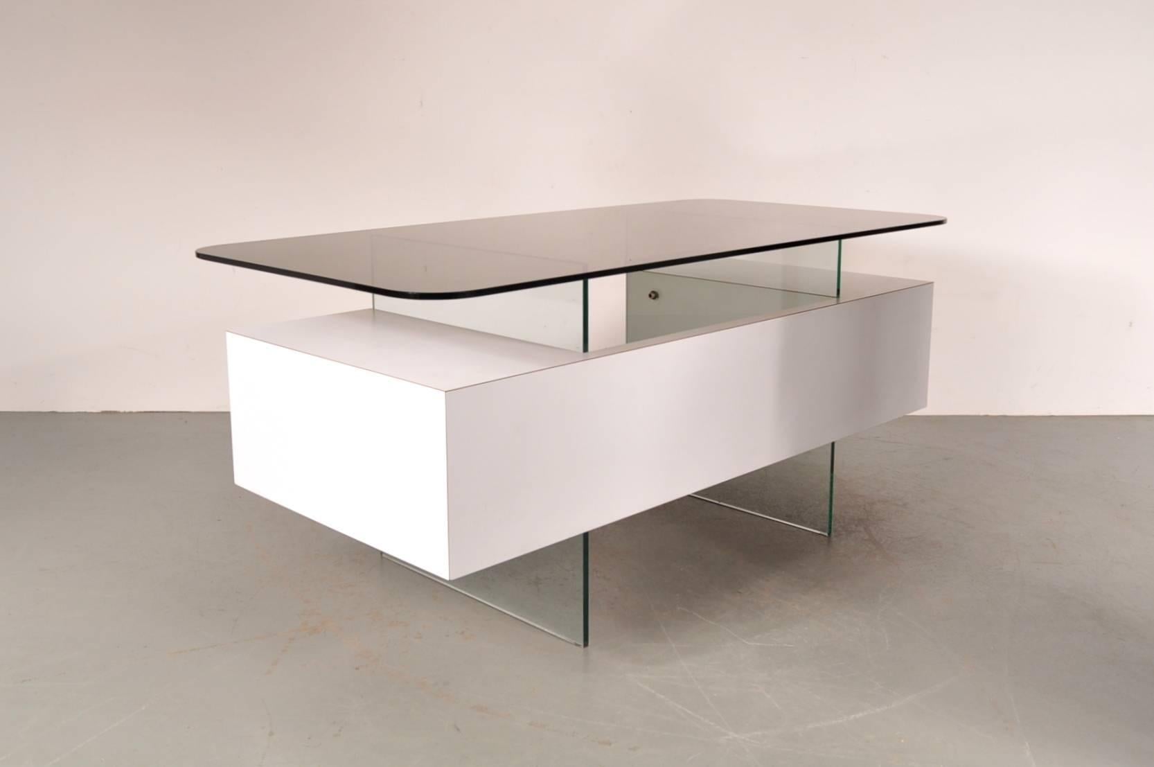 Luxurious executive desk designed by Xavier Marbeau, manufactured in France, circa 1960.

This stunning rare piece that stands out thanks to it's beautiful use of materials. The base is made of glass and wood with a smoke glass top. It creates a