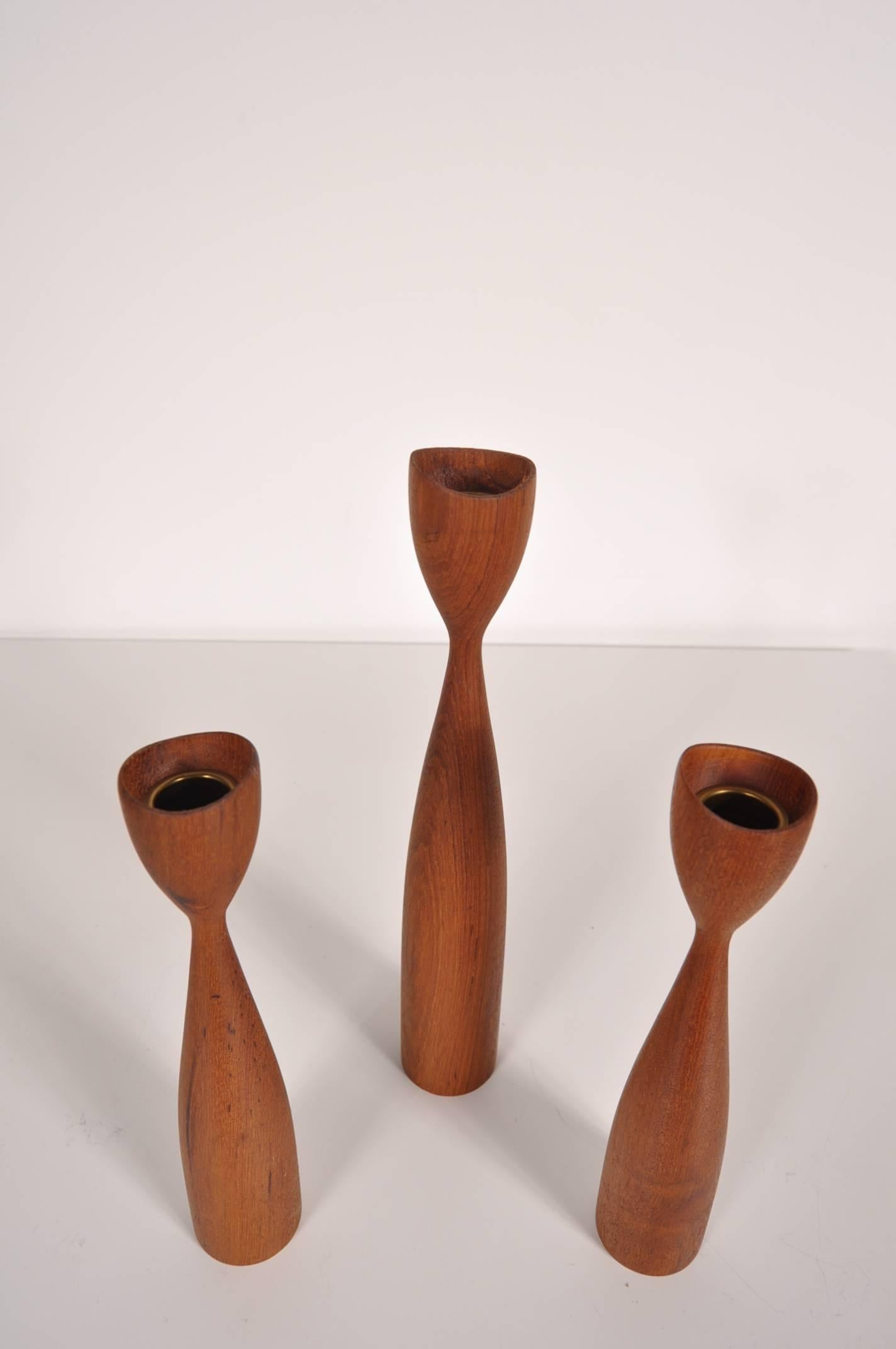 Beautiful set of three candle holders designed in the style of Rude Osolnik, made in Denmark, circa 1950.

These highly recognizable pieces of Danish design are made of high quality teak wood in a rich brown colour. The organic shape that they are