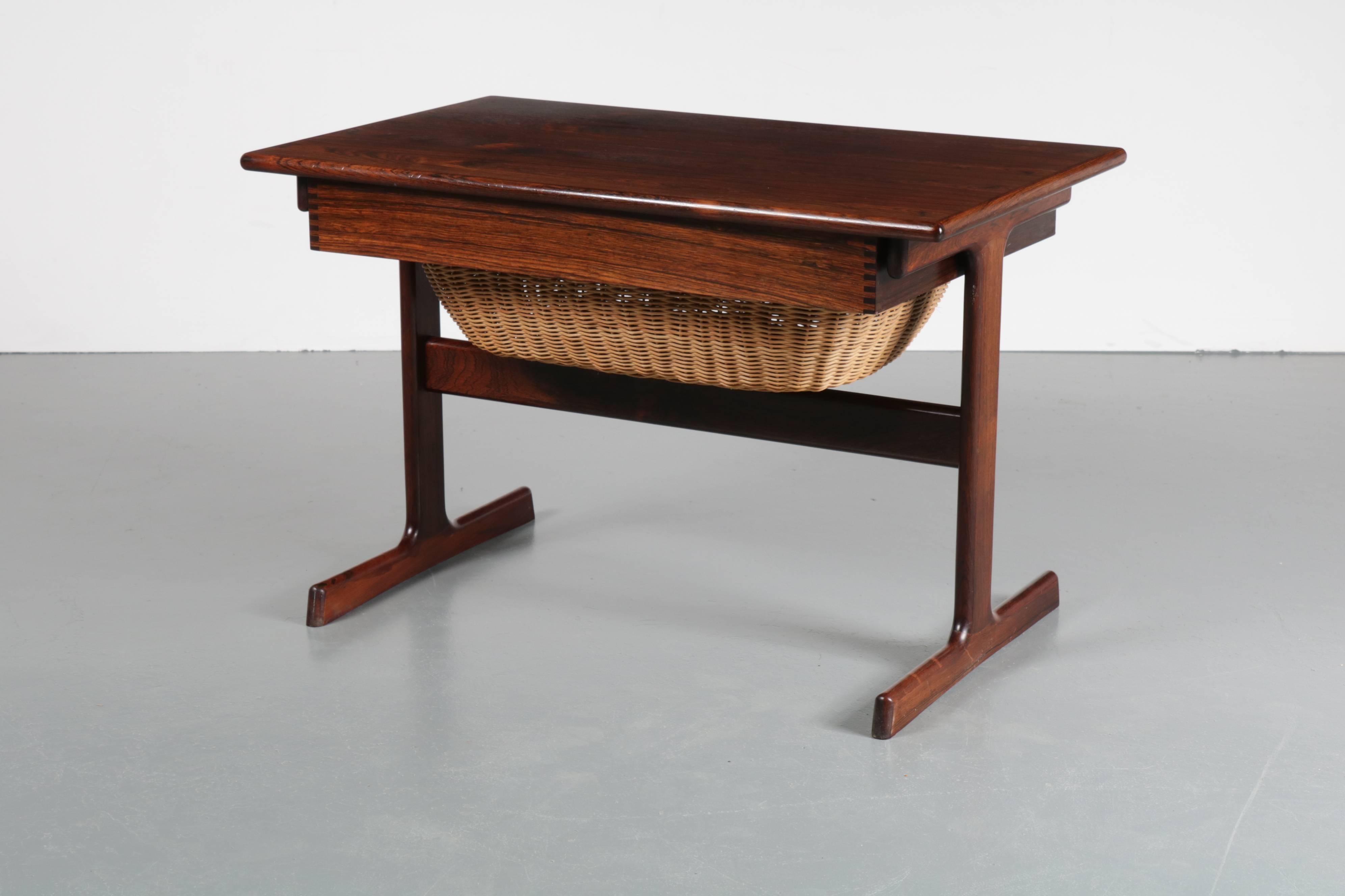 Beautiful sewing box designed by Kai Kristiansen, manufactured by Vildbjerg Møbelfabrik in Denmark, circa 1950.

This beautiful piece is made of high quality tropical hardwood. It is a small table that has a wicker basket and a drawer with several