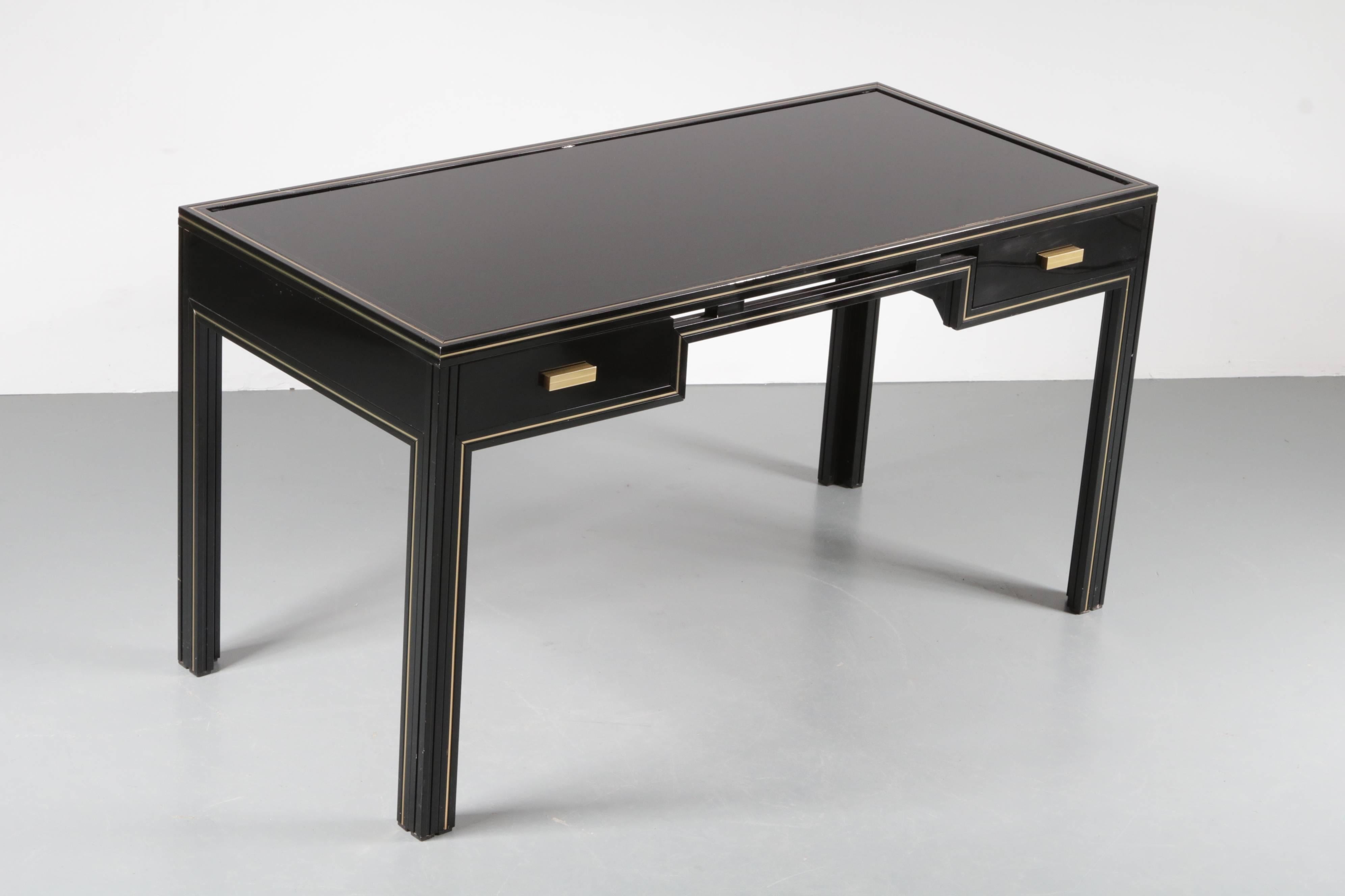 A truly elegant desk designed by Pierre Vandel, manufactured in Paris in the 1970s.

This luxurious piece is made of high quality black lacquered metal with beautiful brass details. The desk has a Minimalist design that is beautifully complimented