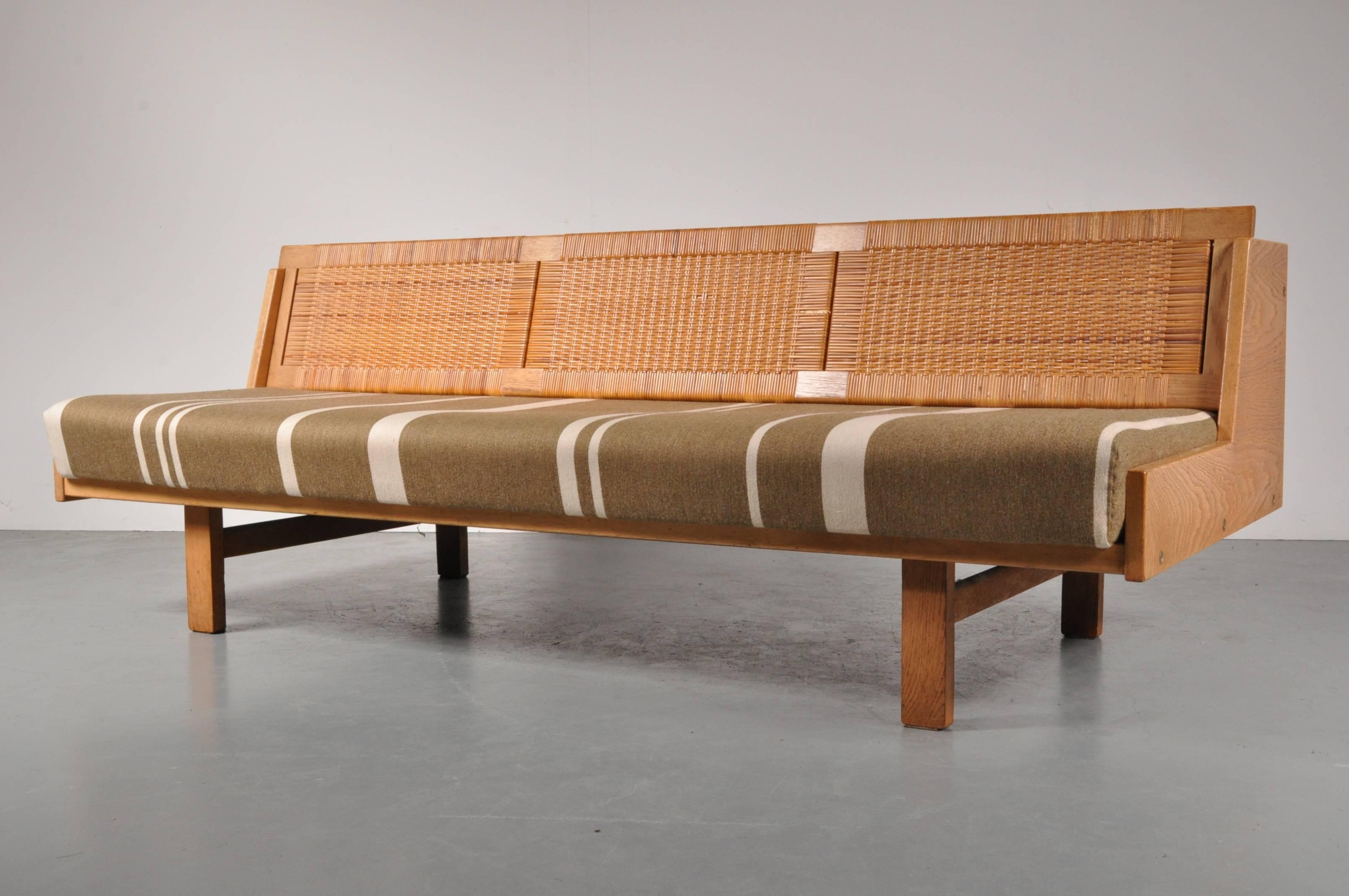 A unique daybed/sleeping sofa designed by Hans J. Wegner, manufactured by GETAMA in Denmark, circa 1950.

This innovative design contains an integrated storage unit in the backrest, revealing a mattress cover to easily convert the sofa into a