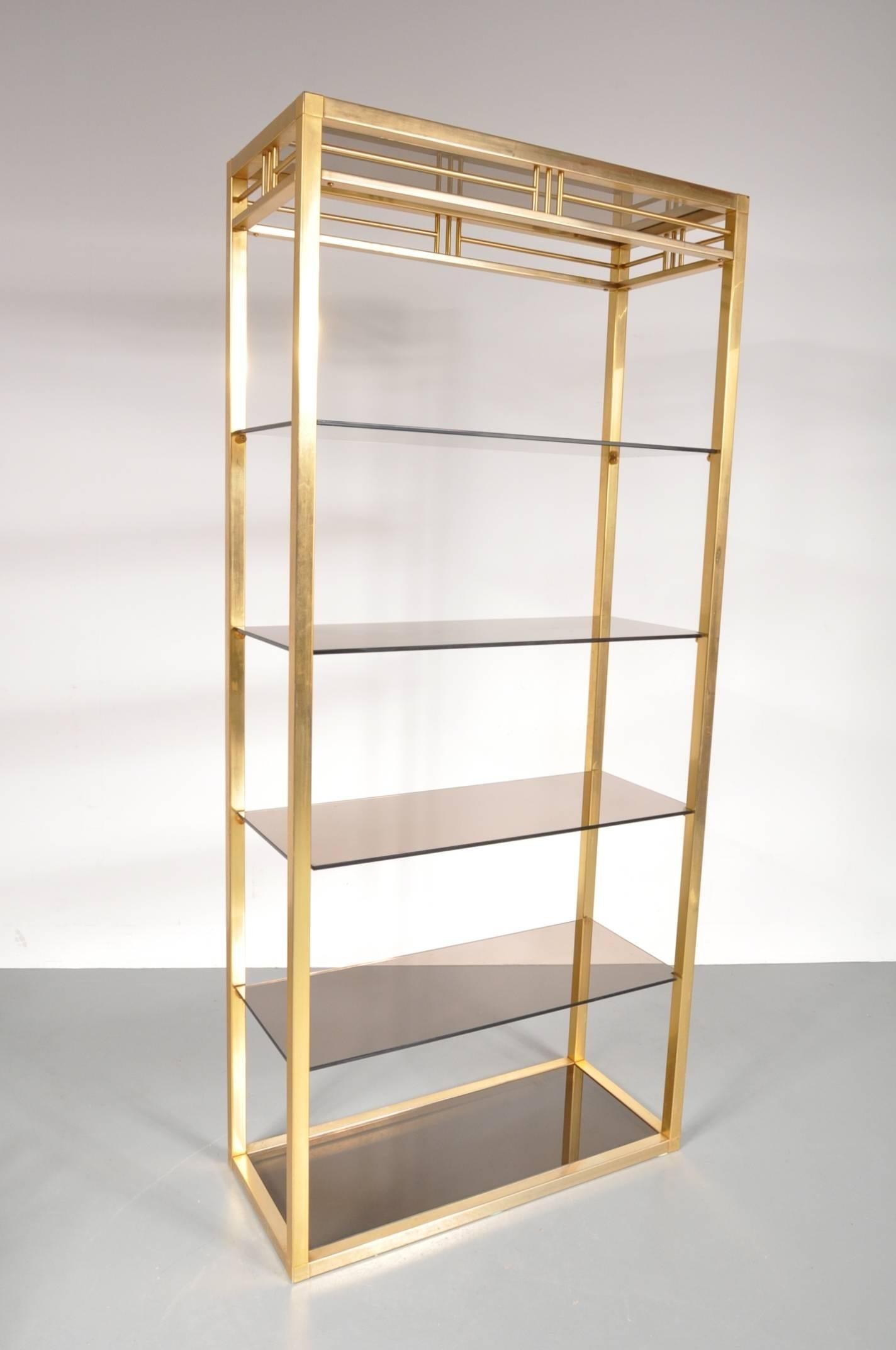 A beautiful, very appealing cabinet produced in Belgium around 1970.

This eye-catching piece is made of high quality brass in a beautiful golden colour, together with the smoke glass creating a wonderful luxurious style! The straight shapes and