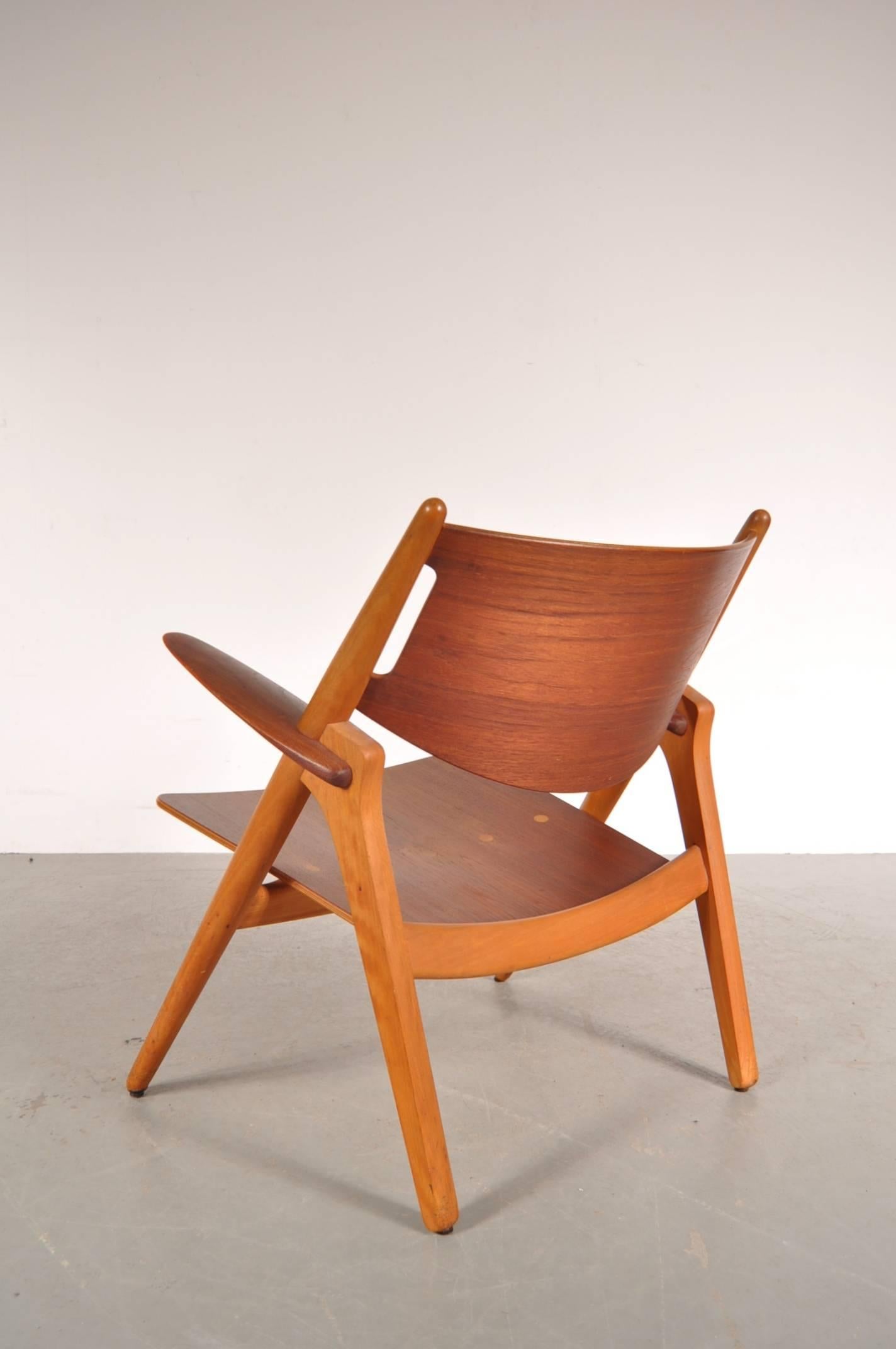 Iconic Sawbuck (model CH-28) easy chair designed by Hans J. Wegner, manufactured for Carl Hansen & Søn in Denmark in 1951.

This beautiful, original chair is made of the highest quality oakwood with a teak wooden seat and back. This use of materials