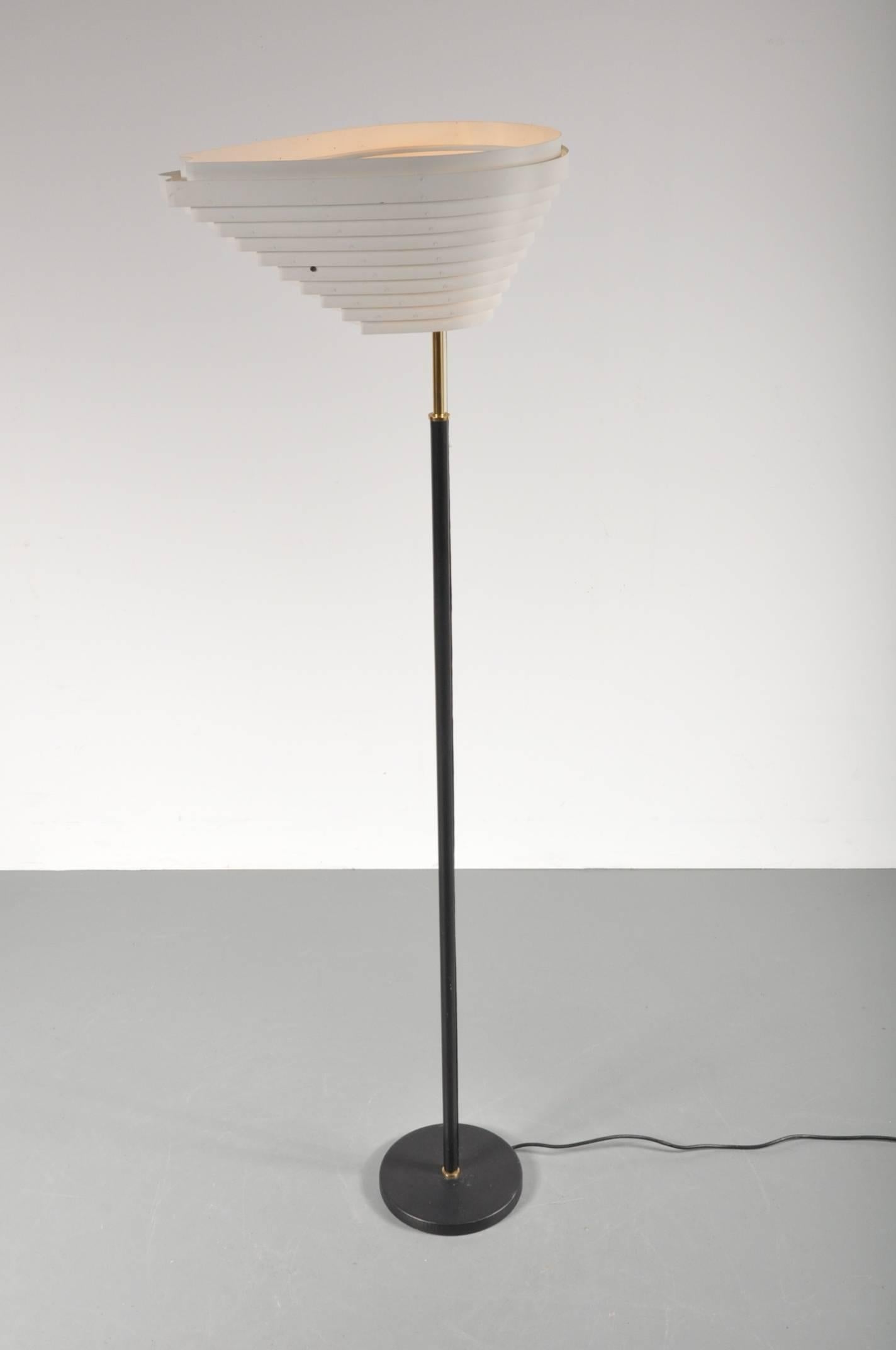Iconic floor lamp by famous Finish designer Alvar Aalto, manufactured by Artek in Finland, in 1956.

This unique design was originally made for Helsinki's Social Insurance Institution Building in 1955. The eye-catching shape of the hood gave it the
