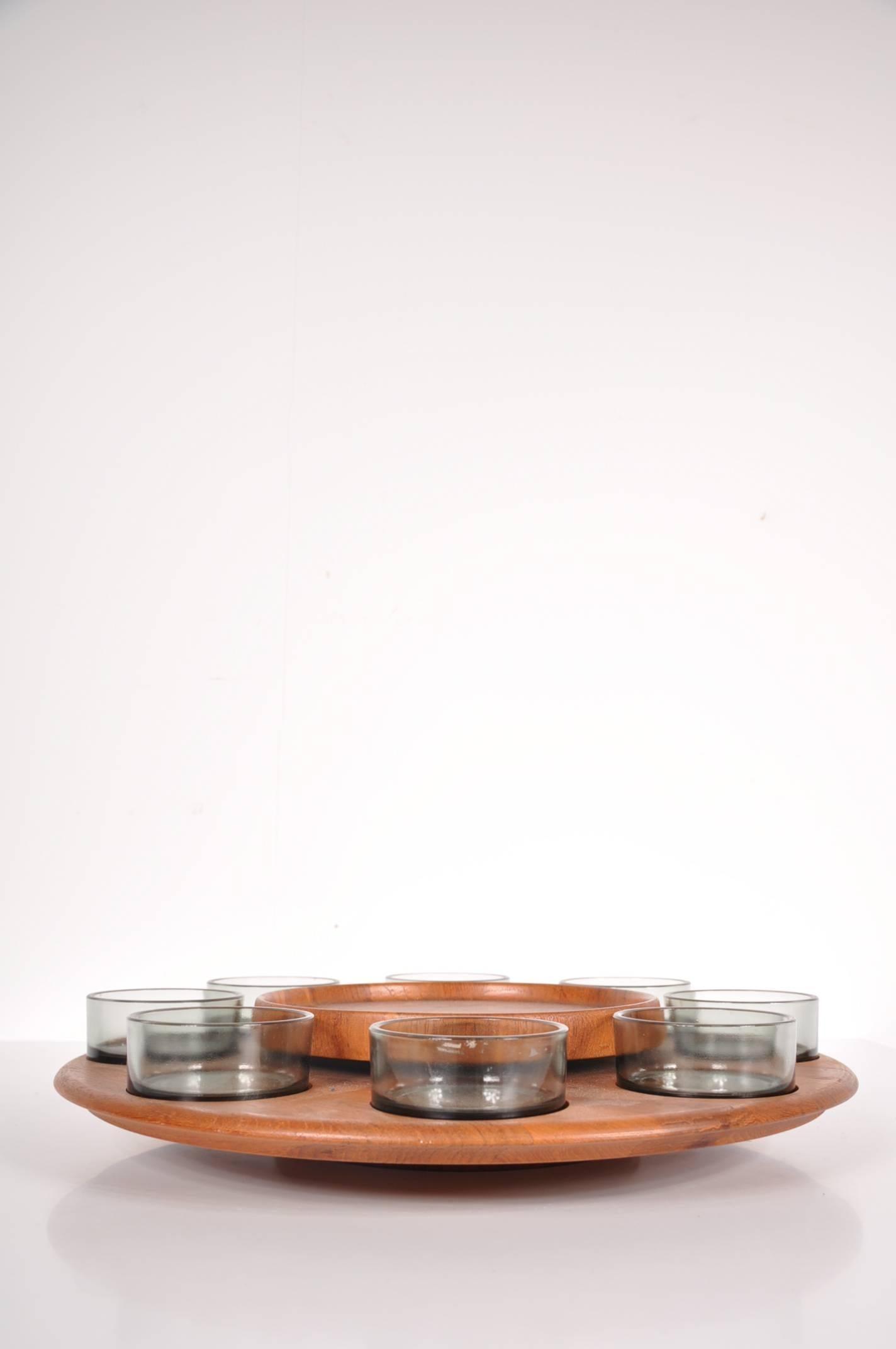 Unique carousel serving tray, manufactured by Digsmed in Denmark around 1950.

This lovely piece is entirely made of teak wood. It holds eight glasses and has a round serving plateau in the middle. The outer circle holding the glasses can be