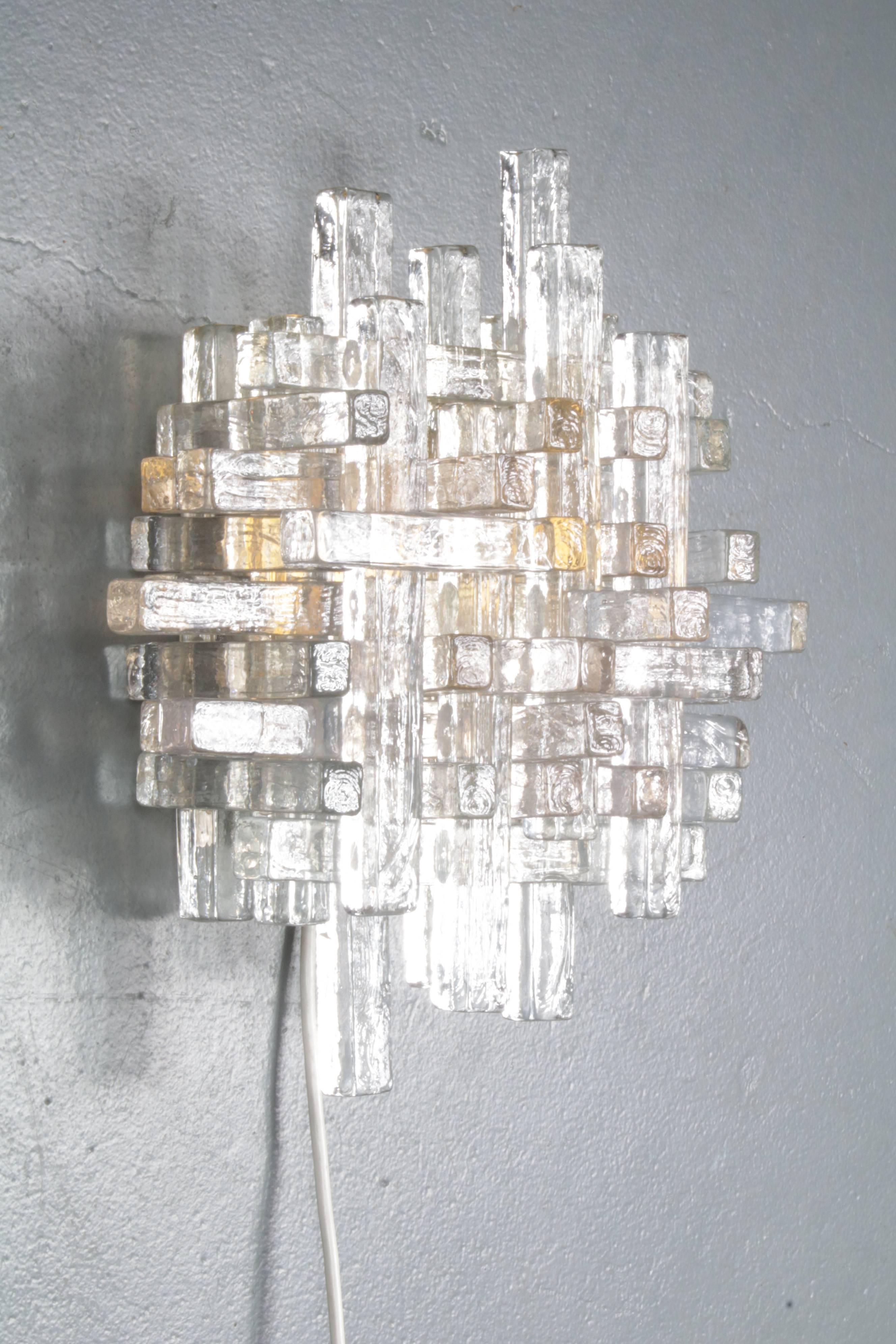A beautiful glass wall sconce manufactured by Poliarte in Italy, circa 1960.

This piece is made of many clear glass rectangular shapes, placed in different positions creating the eye-catching artistic style that Poliarte is famously known form.