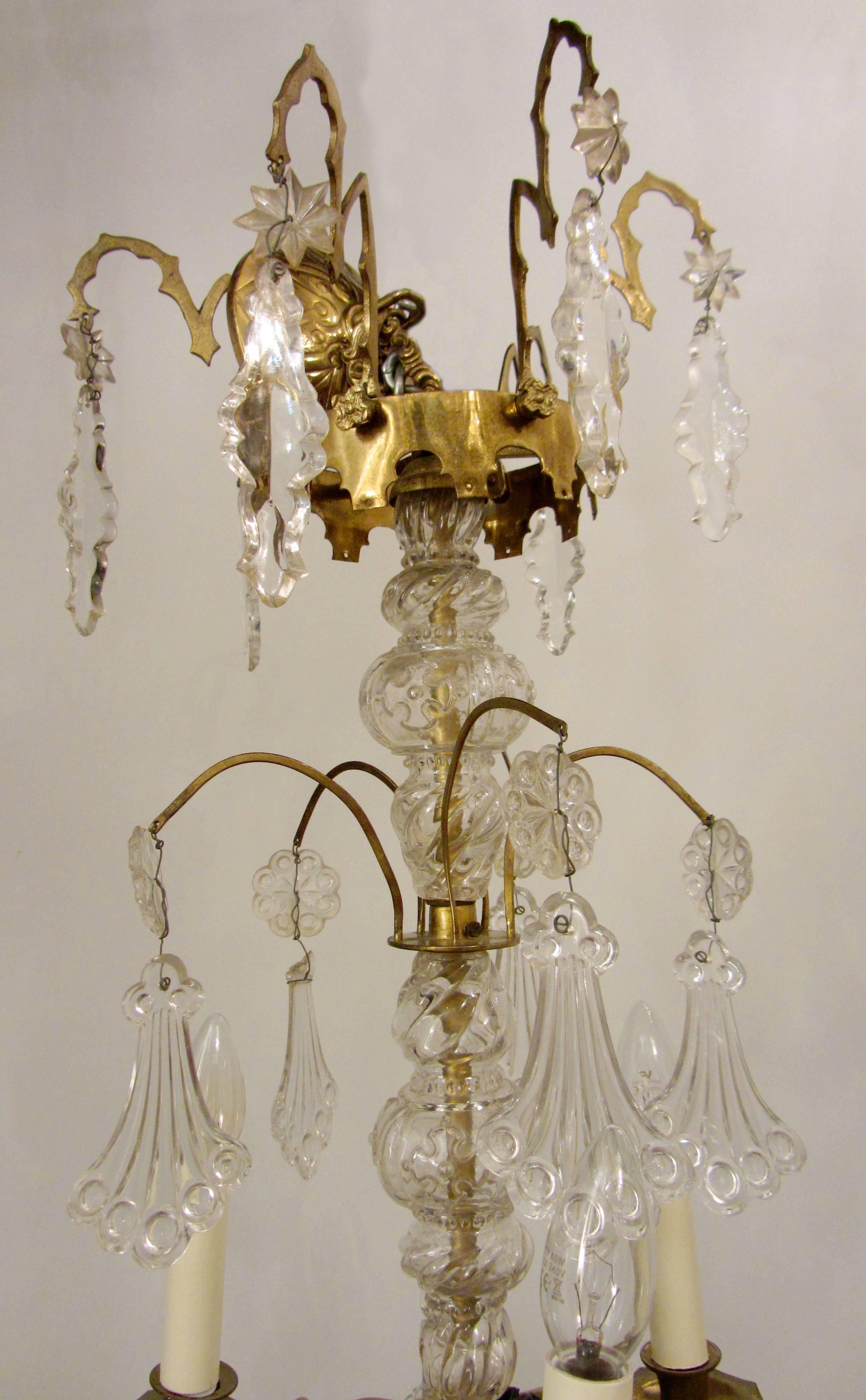 A beautiful Gothic revival, gilt bronze and crystal chandelier. The cut-glass encased stem is interspersed with splays and eight arms of light spread over two tiers. The frame is profusely hung with exquisite 'peacock tail' crystal pendants and