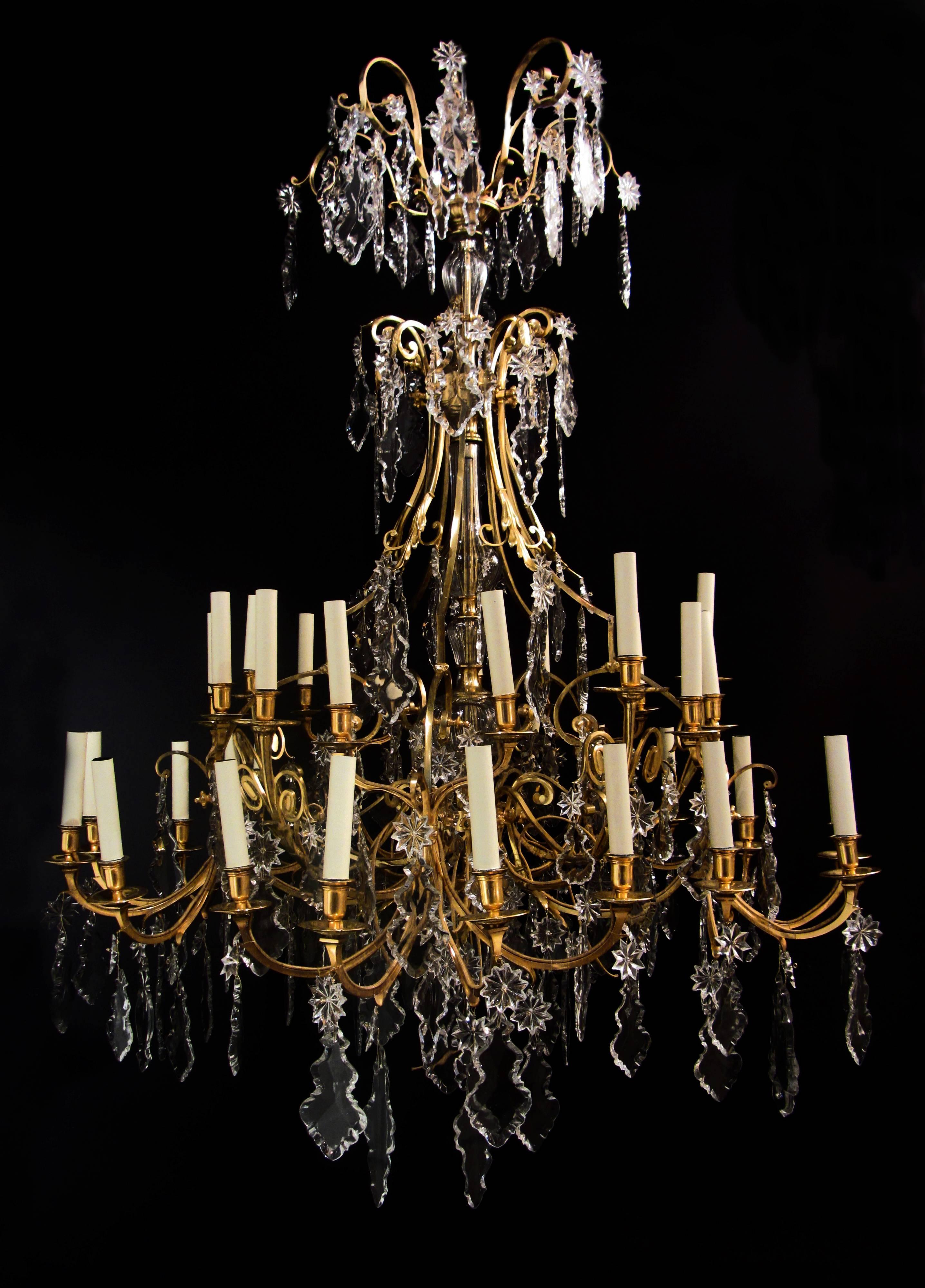 A large and impressive thirty-five light gilt ormolu bronze Louis XVI style chandelier. The central cut glass encased stem supports the arms of light over two tiers, with each scrolling arm and splay profusely decorated with fine quality hand cut