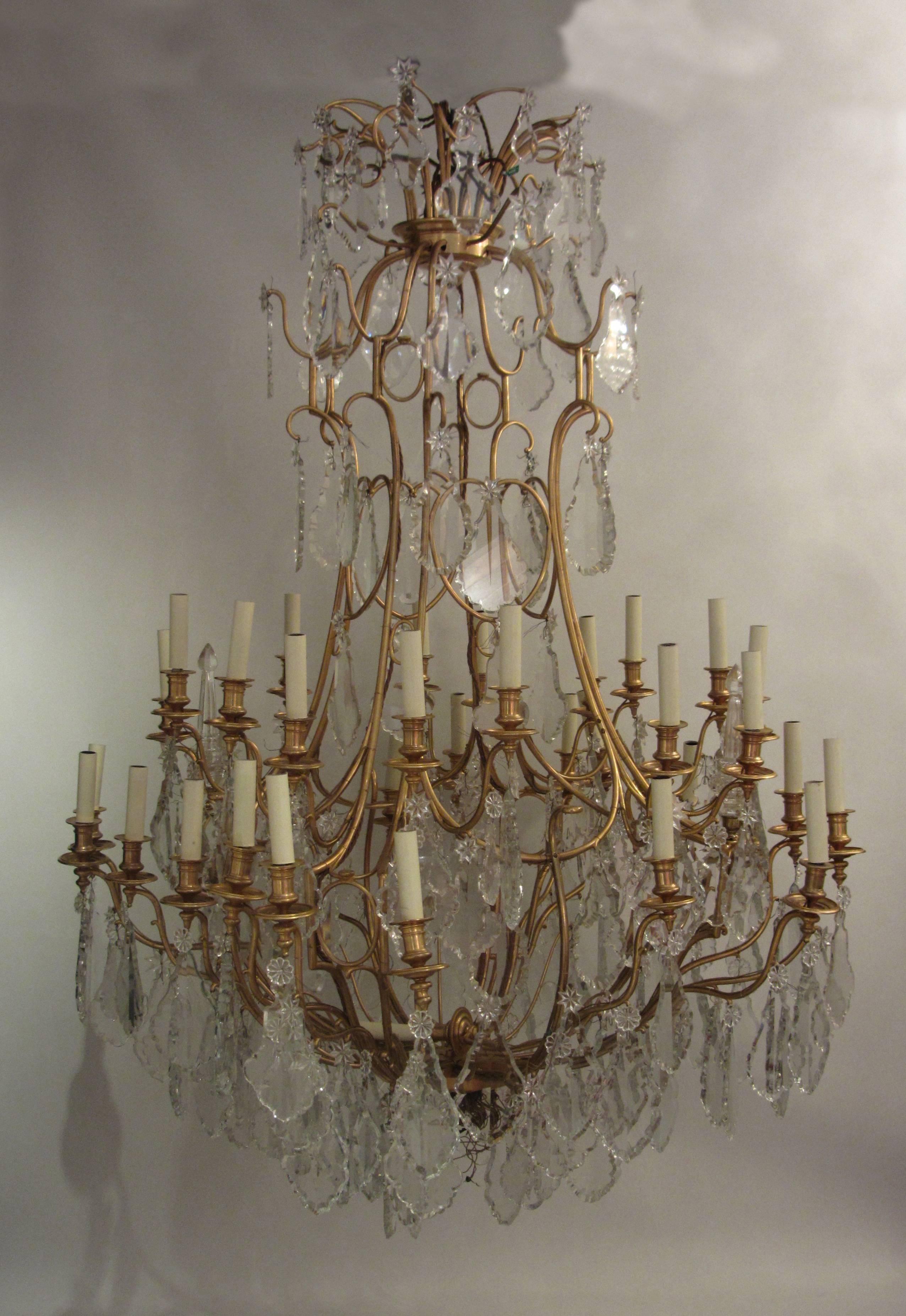 A large-scale, important 19th century Baccarat gilt bronze thirty light chandelier. The bird cage style frame is a Baccarat beautiful decorative design, gold-plated with 22-carat gold and adorned with large excellent quality cut-glass plaques and
