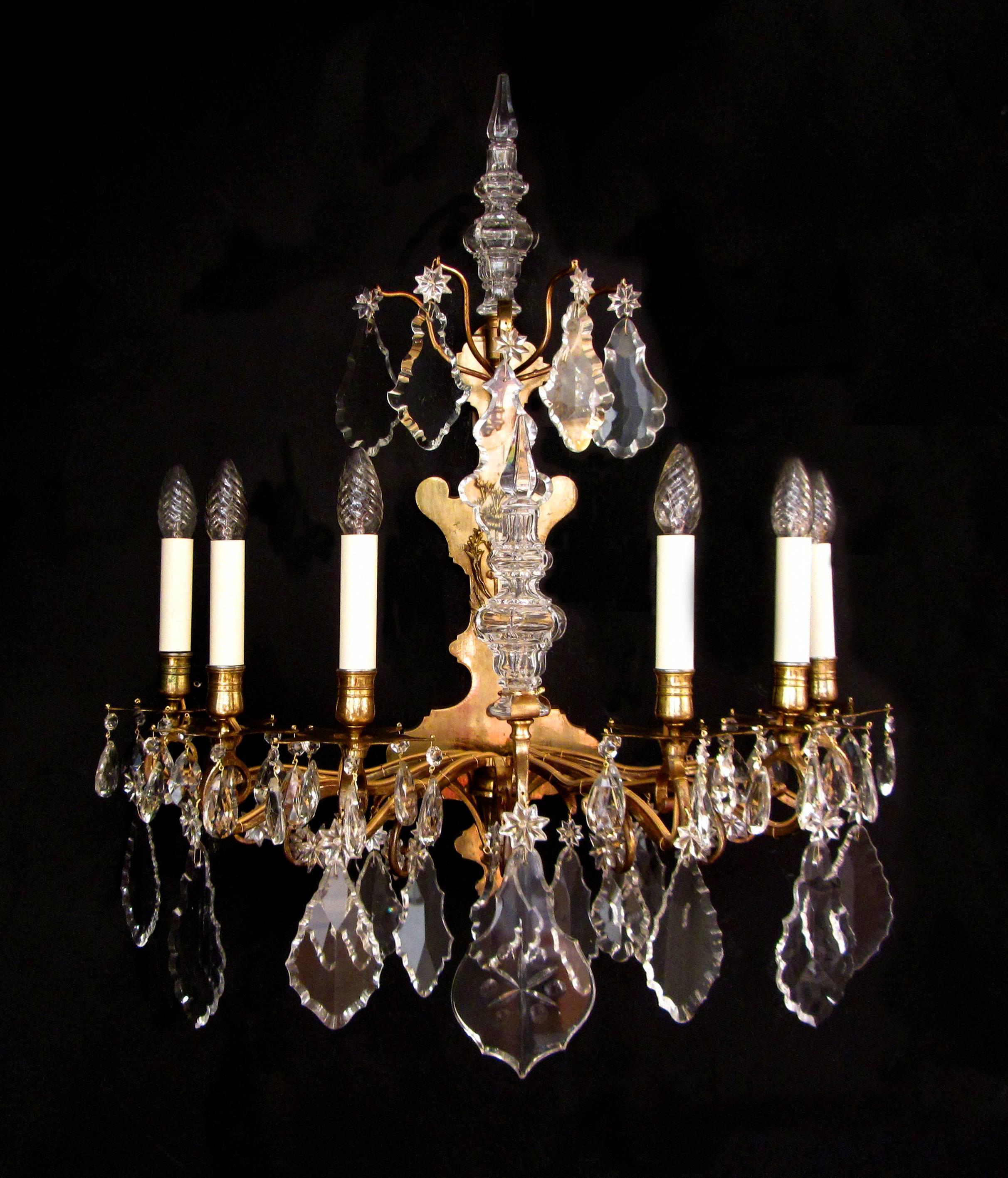 A large pair of French gilt bronze and crystal wall lights. The frame projecting six arms of light with cut-glass plaques, stars and finials, circa 1840.