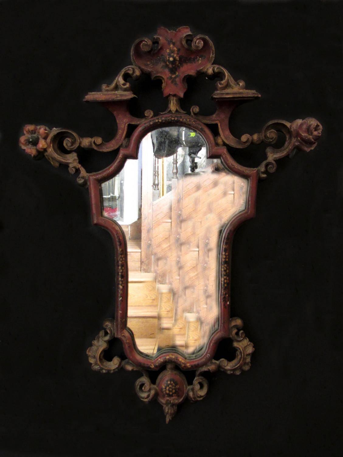 A pair of carved beechwood Sicilian late 19th century mirrors. A reddish brown base with gilding and polychrome floral painting.