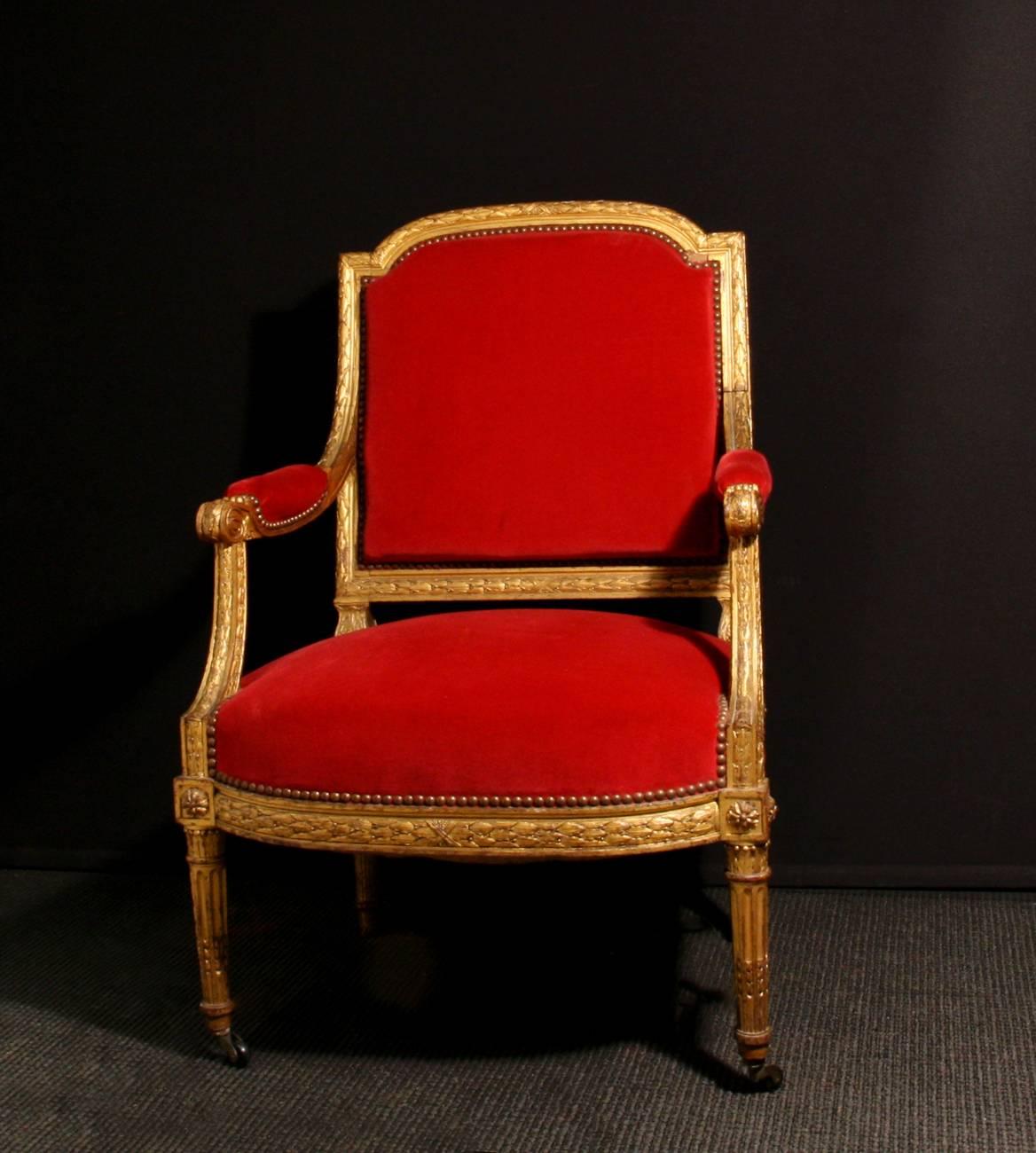 A pair of carved giltwood Louis XVI style fauteuil, upholstered with red velvet.

Measures: Seat height 40cm.