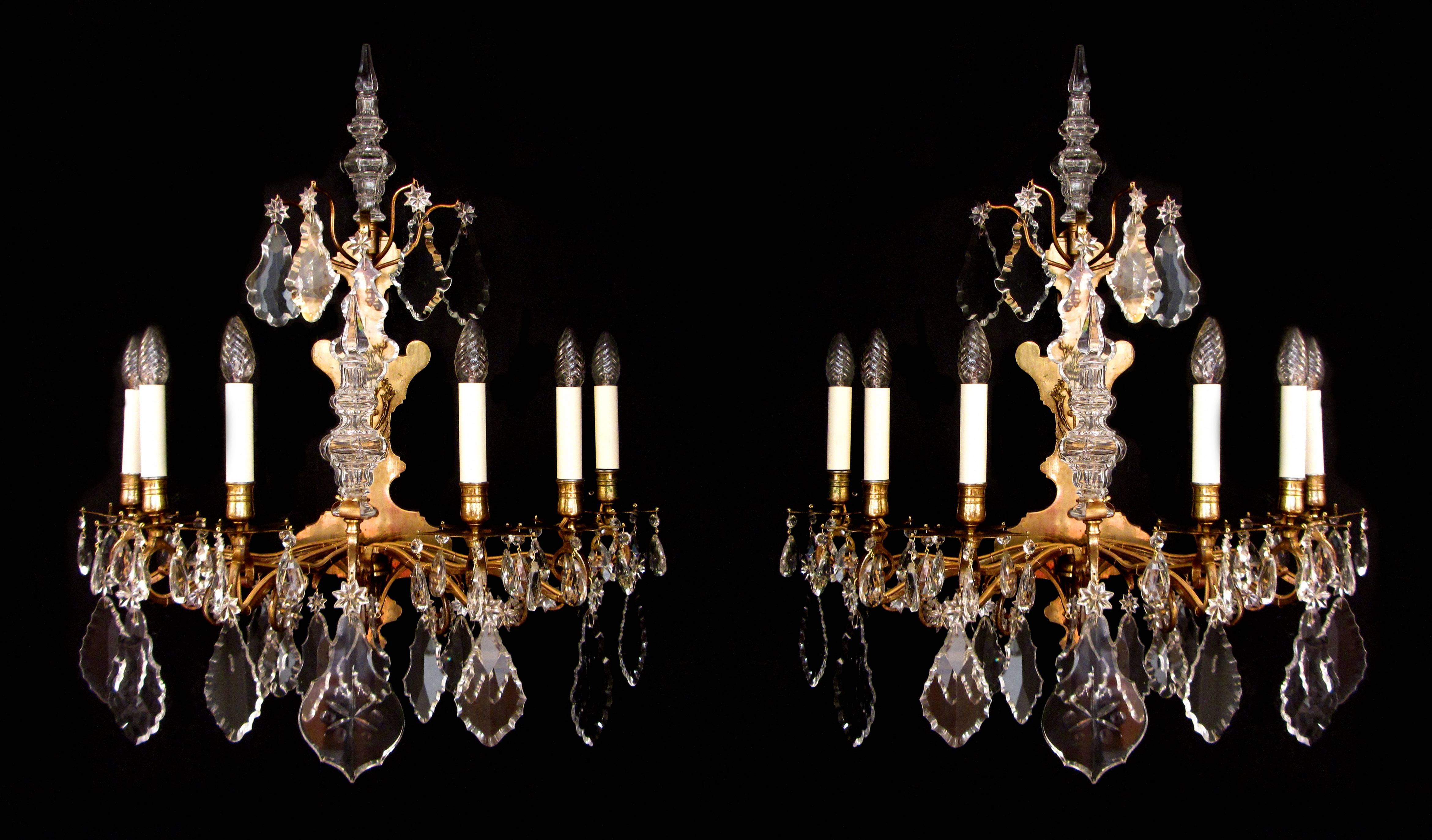 A large pair of French gilt bronze and crystal wall lights. The frame projecting six arms of light with cut-glass plaques, stars and finials, circa 1840.