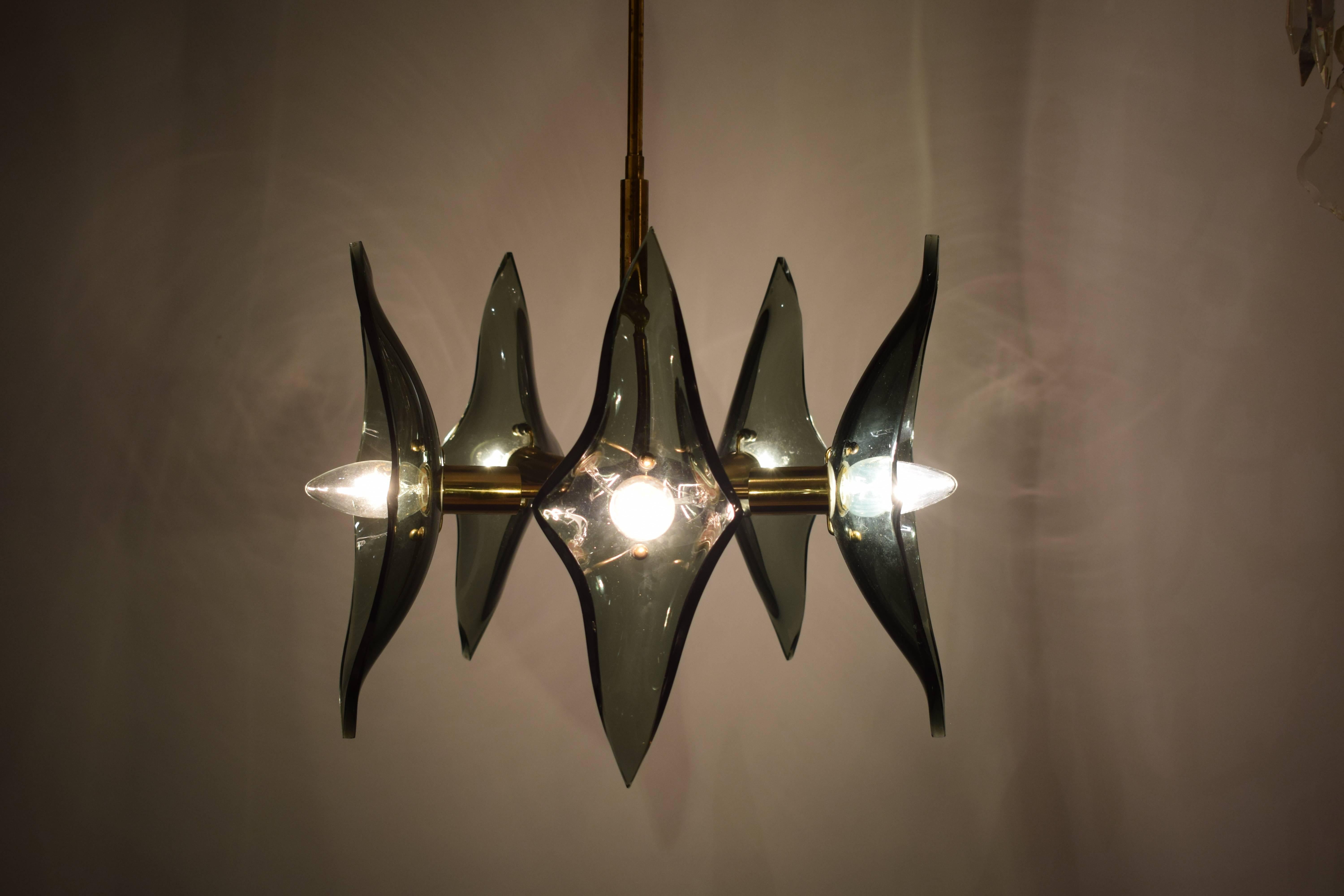 A stunningly elegant chandelier attributed to Fontana Arte. Clear and smoked beveled glass panels, with an armature of brass polished well but showing signs of age and use. Small but heavy. Exceptional quality.

Measured to the top of the canopy.