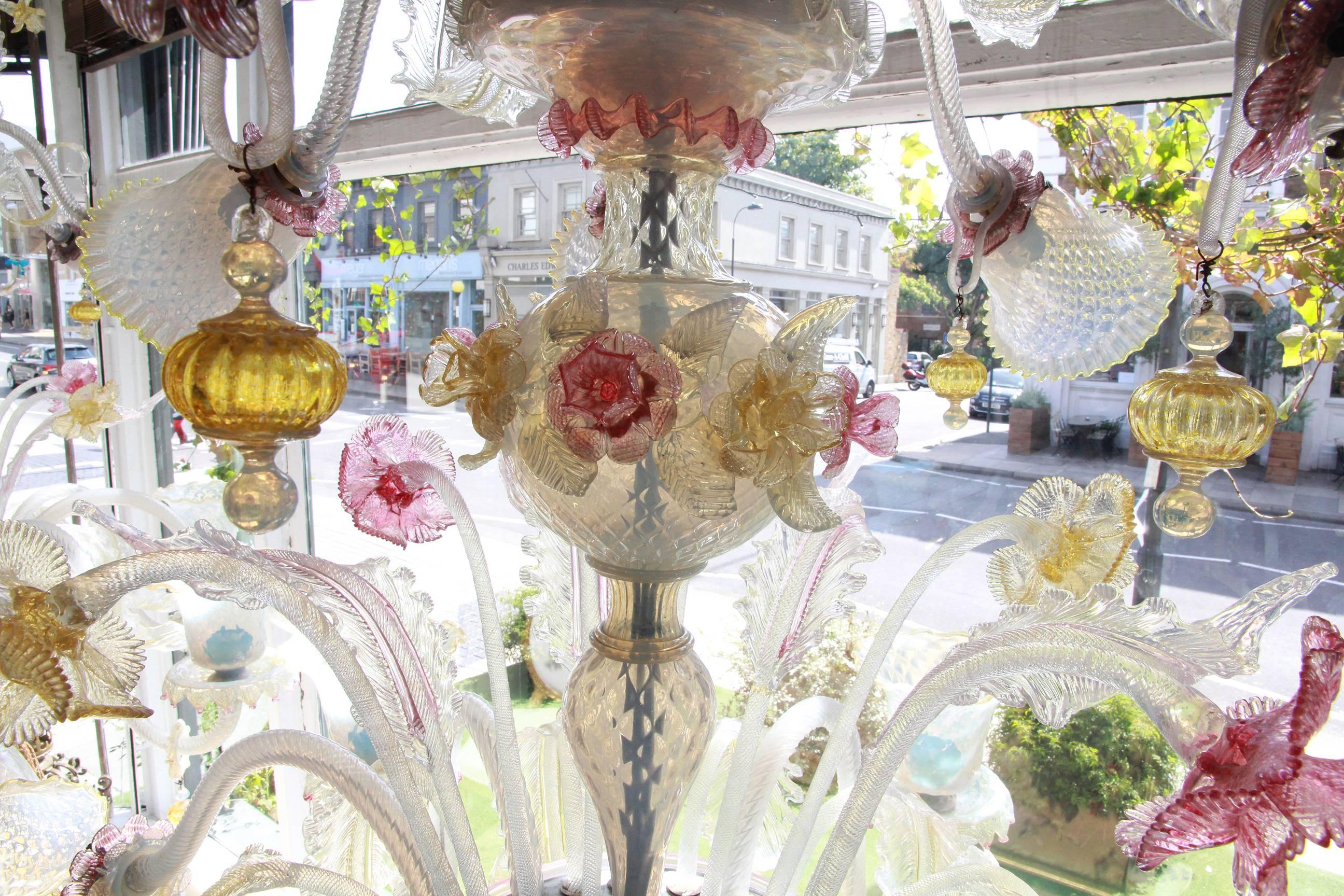 A pair of large Venetian opaque and colored glass fifteen-light chandelier, the s-shaped branches with frilled opaque shades and polychrome flower heads and foliage issuing from a central stem.