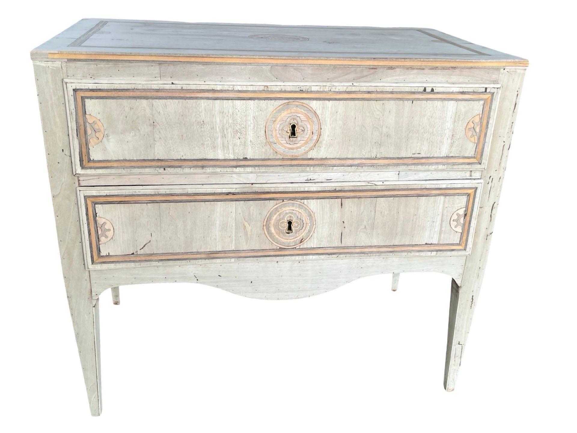 Neoclassical commode hand-made in Italy in the mid 1900s using walnut and decorated with walnut veneer. The commode is very straight in lines and features two overlay drawers with ogee edges and flat drawer fronts. along the edge of the drawer