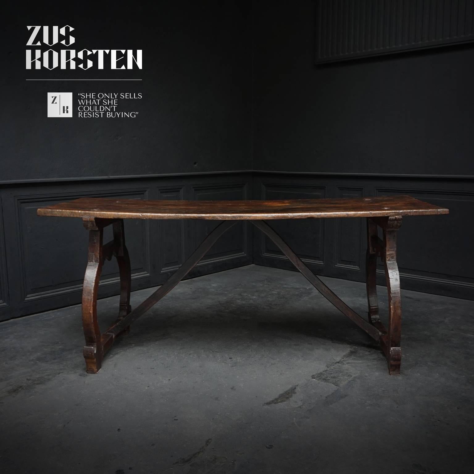 This chestnut refectory table with lyre or harp form supports and original wooden stretchers will easily seat six or even eight people for dinner. The tabletop is mounted to the legs with four large visible iron nails. Its robust but elegant style