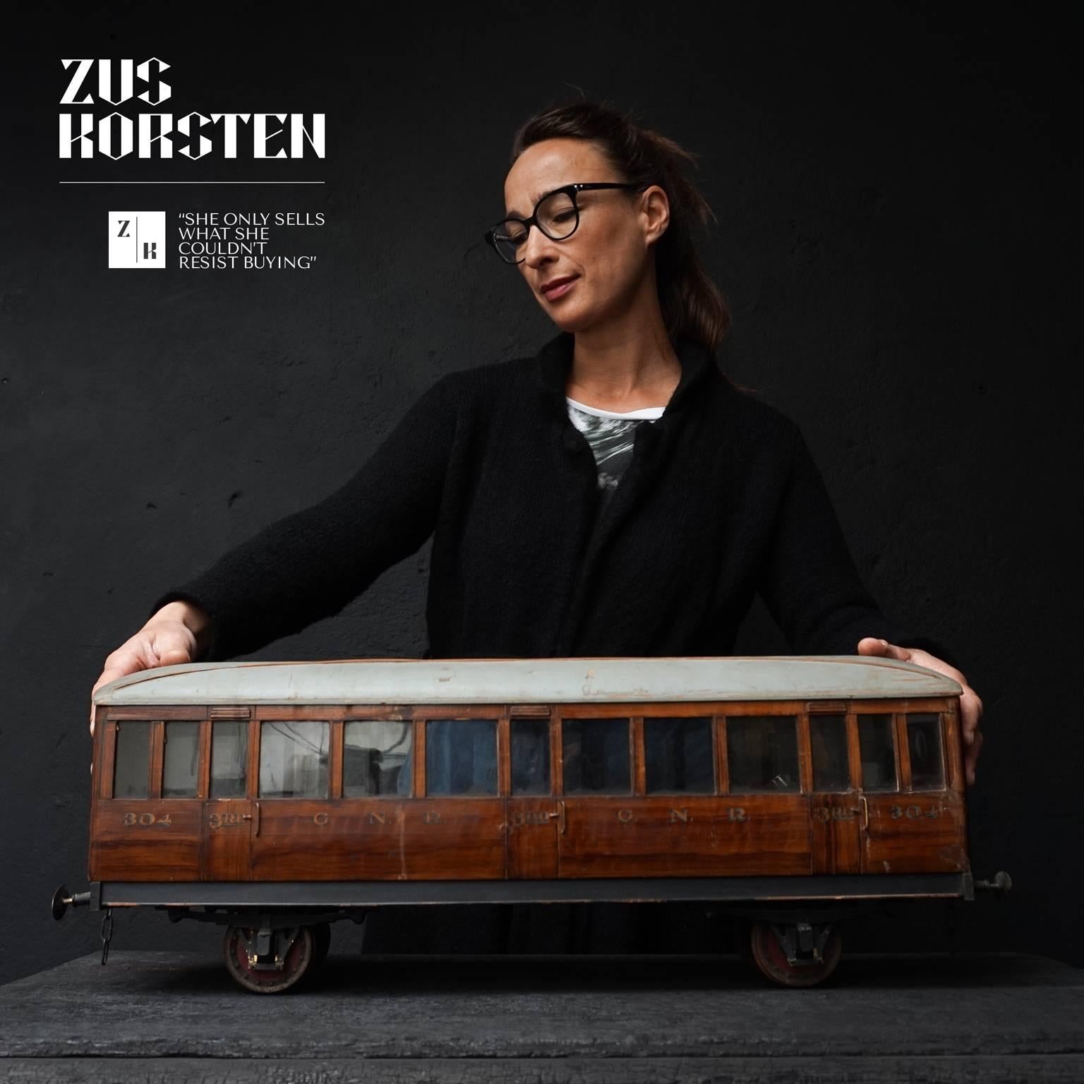 This large scale model train compartment is made of painted wood, even the roof is made of wood. Except for the small very lifelike metal parts like leaf-springs, wheels and bumpers, which actually work (it rolls and bumps) and the early plastic