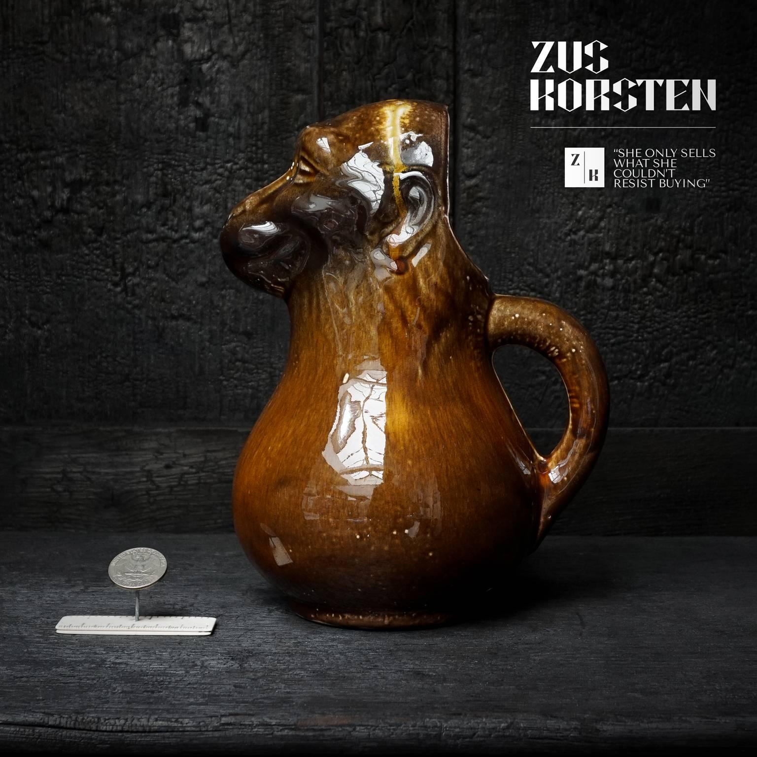 Look at the color and shape, what an awesome piece.

This pitcher is in the shape of a monkey with his mouth being the spout and his tail the handle. There is an opening at the back of his head where it can be filled with water, to add to your