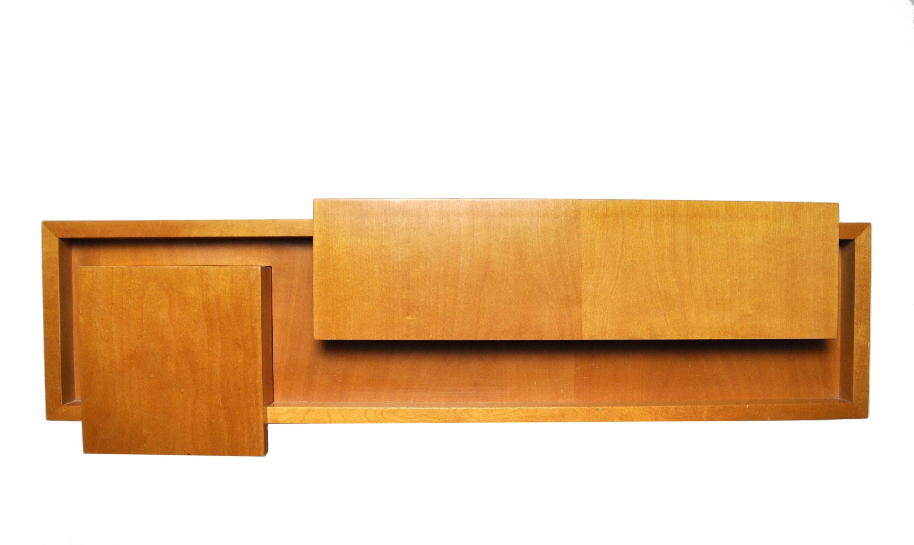 A wall-mount construct highly grained in the modernist vein. The handsomely crafted draw handle articulates the language of the Swiss modernist ideal of function follows form. The lid of the over hang opens to reveal a simple mirror within a
