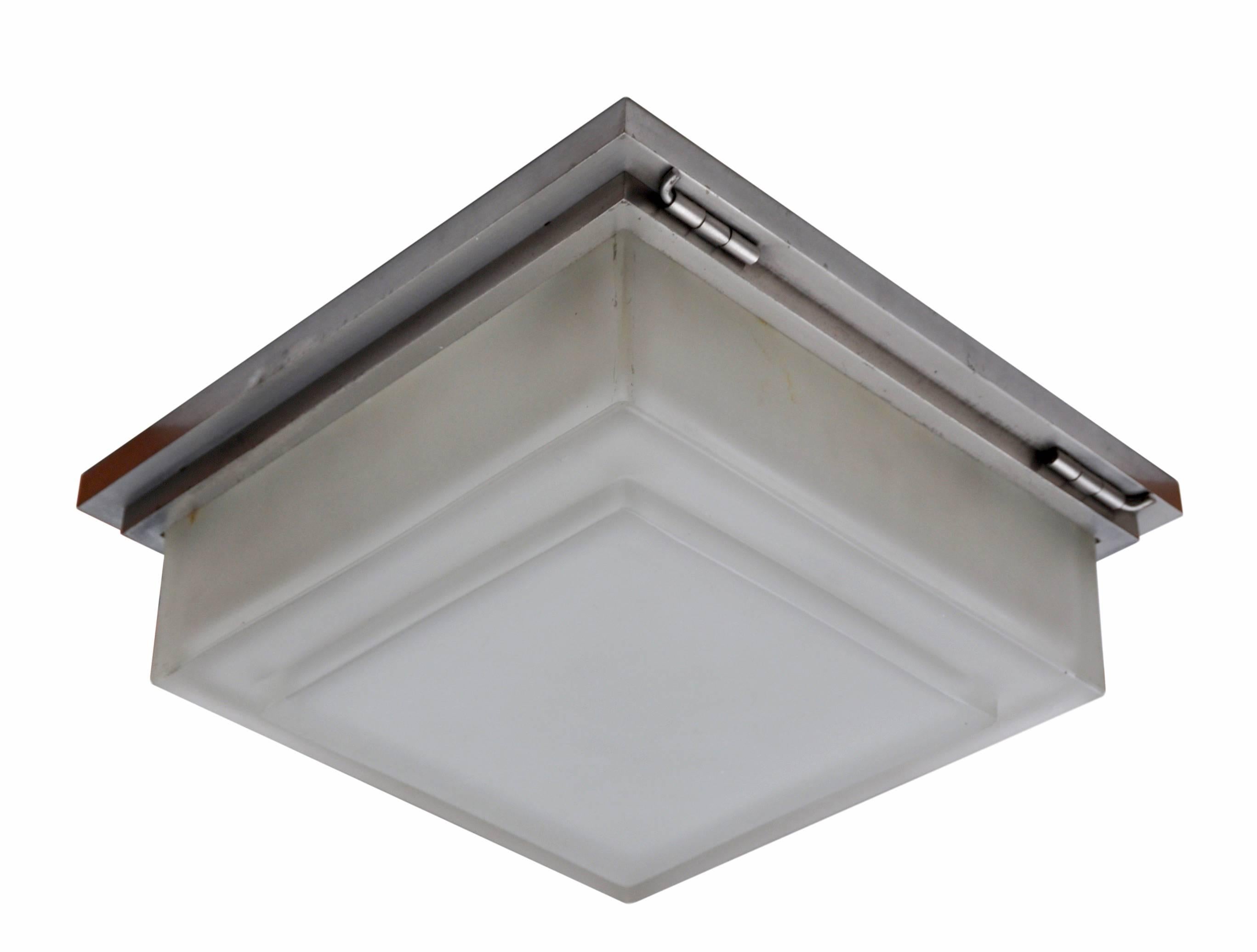 Modernist flush mount with thick acid etched glass sitting within an equally robust nickeled brass frame. There are four high quality brass sockets within fitting E26 light bulbs. The choice of materials marries masterfully to the strict layered