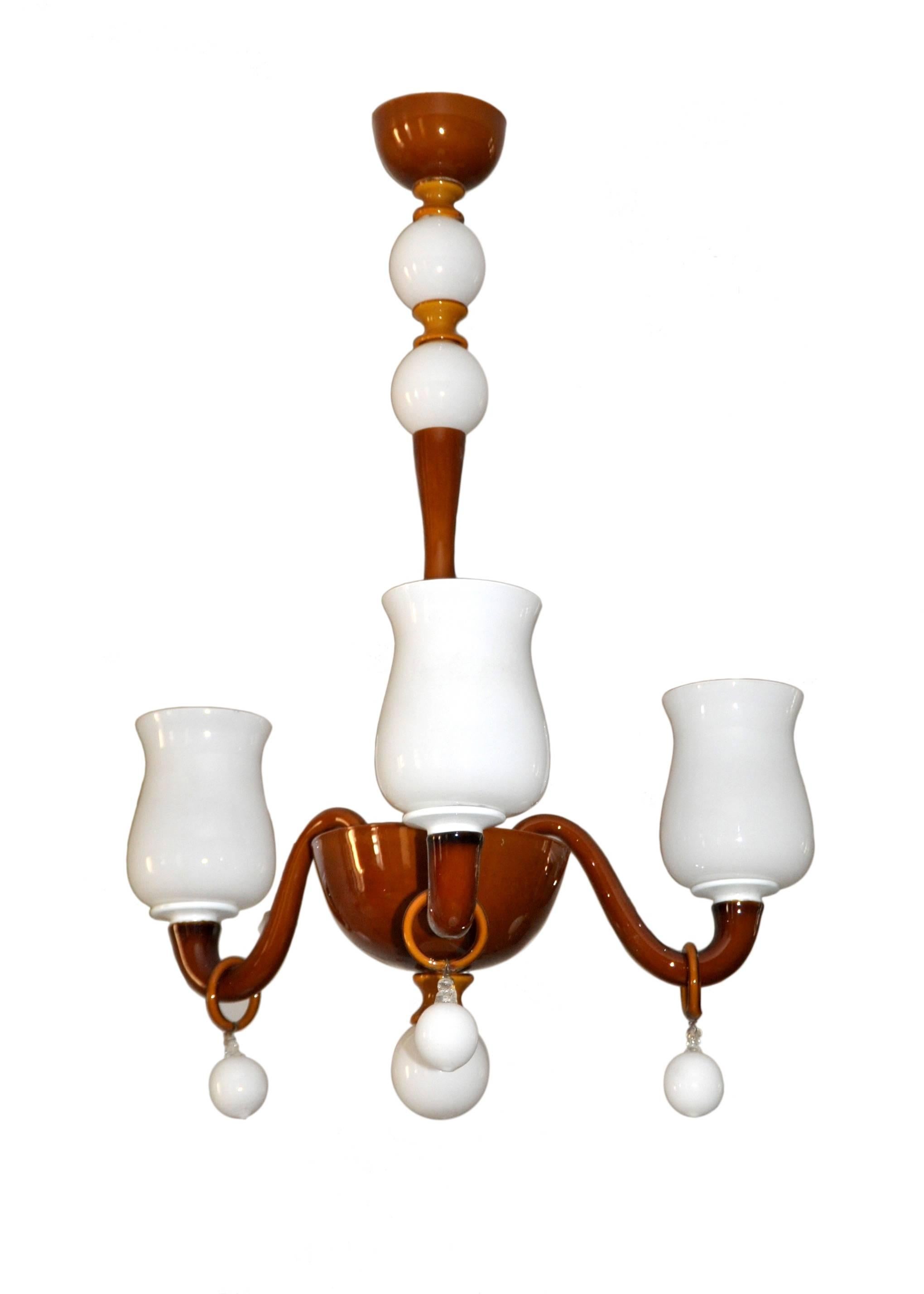 A scale down caramel with white lattimo three-arm Venini chandelier.
 