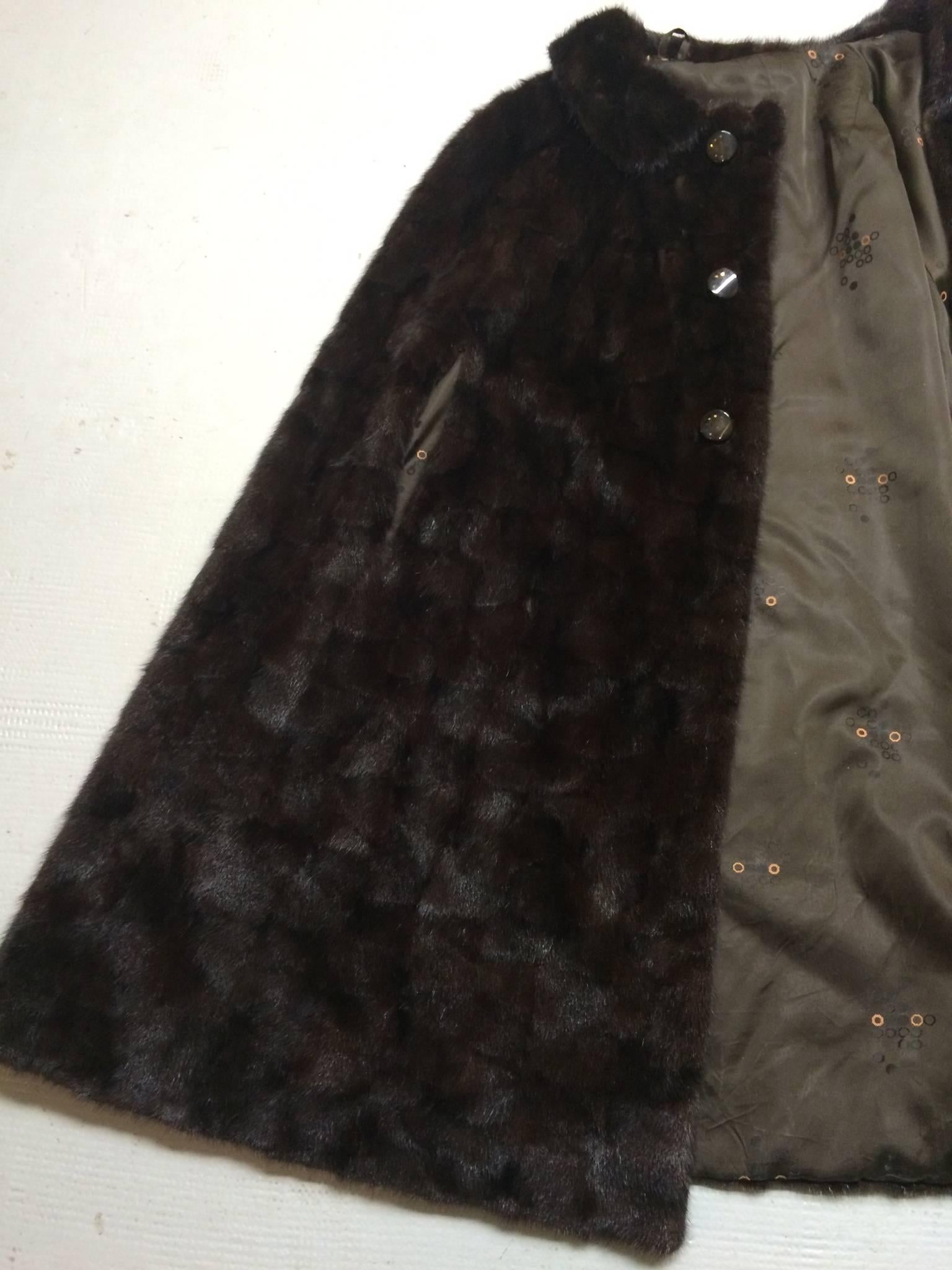 Timeless glamorous mink cape in beautiful shades of rich brown.
The heavy satin of the lining is adorned with a classical 50's floral design.
No damage on the lining.
43 inches long from back collar to hem (110cm).
Closes with invisible hooks