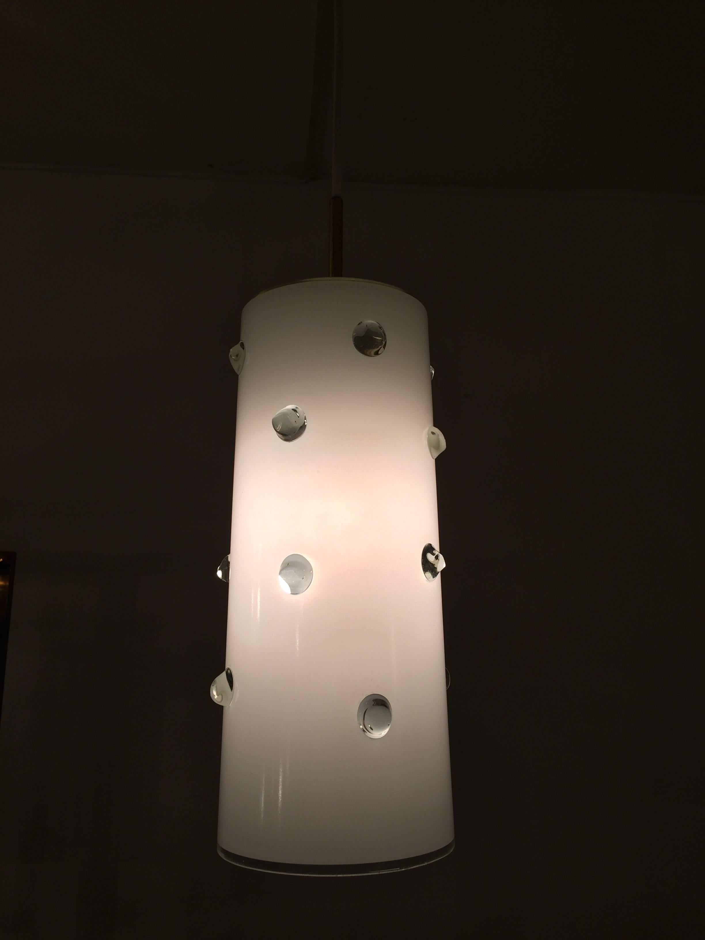 Lampe suspendue en verre et laiton par Vistosi, Italie, vers les années 1960.
Belle condition.
Cylindre en verre de 16 cm de diamètre et de 34 cm de hauteur.