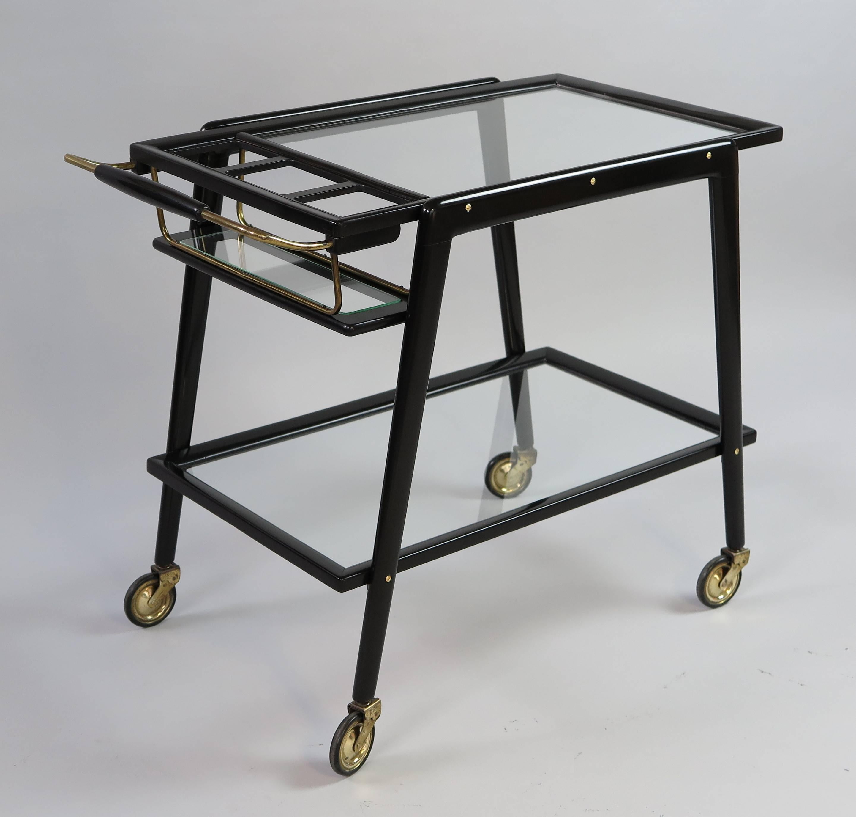 Bar trolley with bottle holder, black lacquered wood, brass, glass shelves,
manufactured in Italy in the 1950s, attributed to Cesare Lacca.