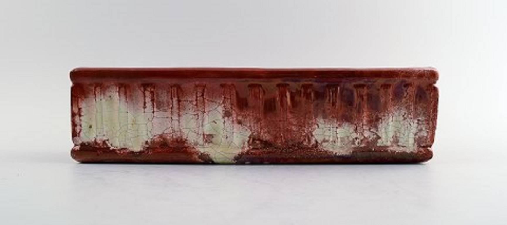 Kähler, Dänemark, Blumentopfhalter / Jardiniere aus glasiertem Steingut in roter Glanzglasur.

Ungefähr 1910er Jahre.

In perfektem Zustand.

Markiert.

Maße: 29 x 7,5 cm.