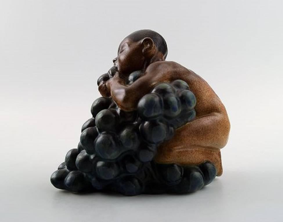 Bing & Grondahl, stoneware figurine of boy with bunch of grapes by Kai Nielsen (1882–1924).

Model number 4021.

From the series 'Grape Harvesting.'

Measures: 10.5 cm. x 9.5 cm.

Quality, in perfect condition.