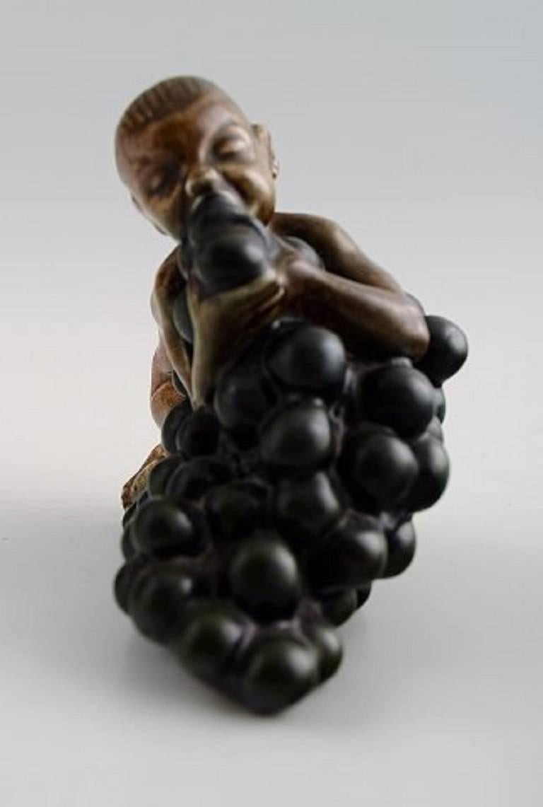 Bing & Grondahl figurine of boy with bunch of grapes by Kai Nielsen (1882–1924).

Model number 4027. 

From the series 'Grape Harvesting'.

Measures 10.5 cm. x 9.5 cm.

1. Quality, in perfect condition.
