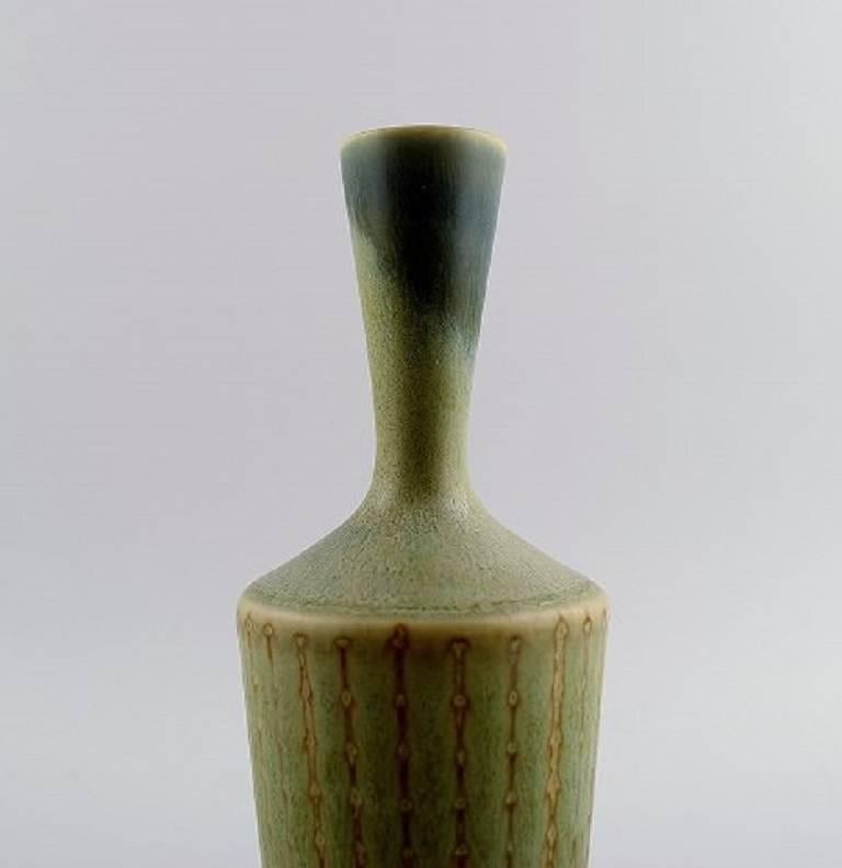 Berndt Friberg studio hand art pottery vase with a narrow neck.

Modern Swedish design. 

Unique, handmade. In fluted design.

Amazing glaze in green shades with brown lines.

Marked F = year 1964.

Perfect 1st. factory quality.

Size: 18 cm, high 6