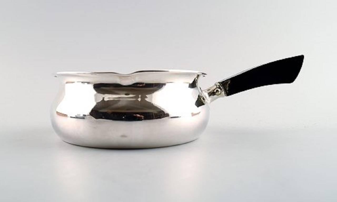 Two Danish silver saucepans, Jens Sigsgaard,.

In good condition. One handle is lighter worn.

Marked.

Measures: 28.5 cm. x 7 cm. and 19 cm. x 5 cm.