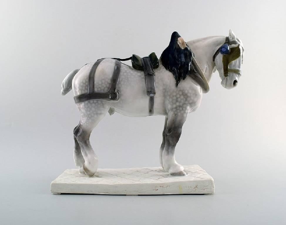 Percheron horse / French workhorse in harness, Royal Copenhagen figurine. 

No. 471.

Measures: Height 29 cm., width 35 cm.

Type: Underglaze.

Designed by: Carl J. Bonnesen.

1. Quality, in perfect condition.