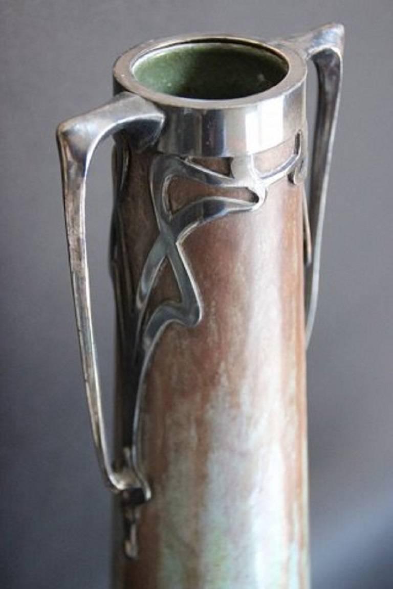 Austrian Art Nouveau work, 1900.

Stoneware vase in flamed glaze, silver plate stylish decor of plants forming the handles. 

Height: 36 cm. 

In good condition.

Apparently unmarked.