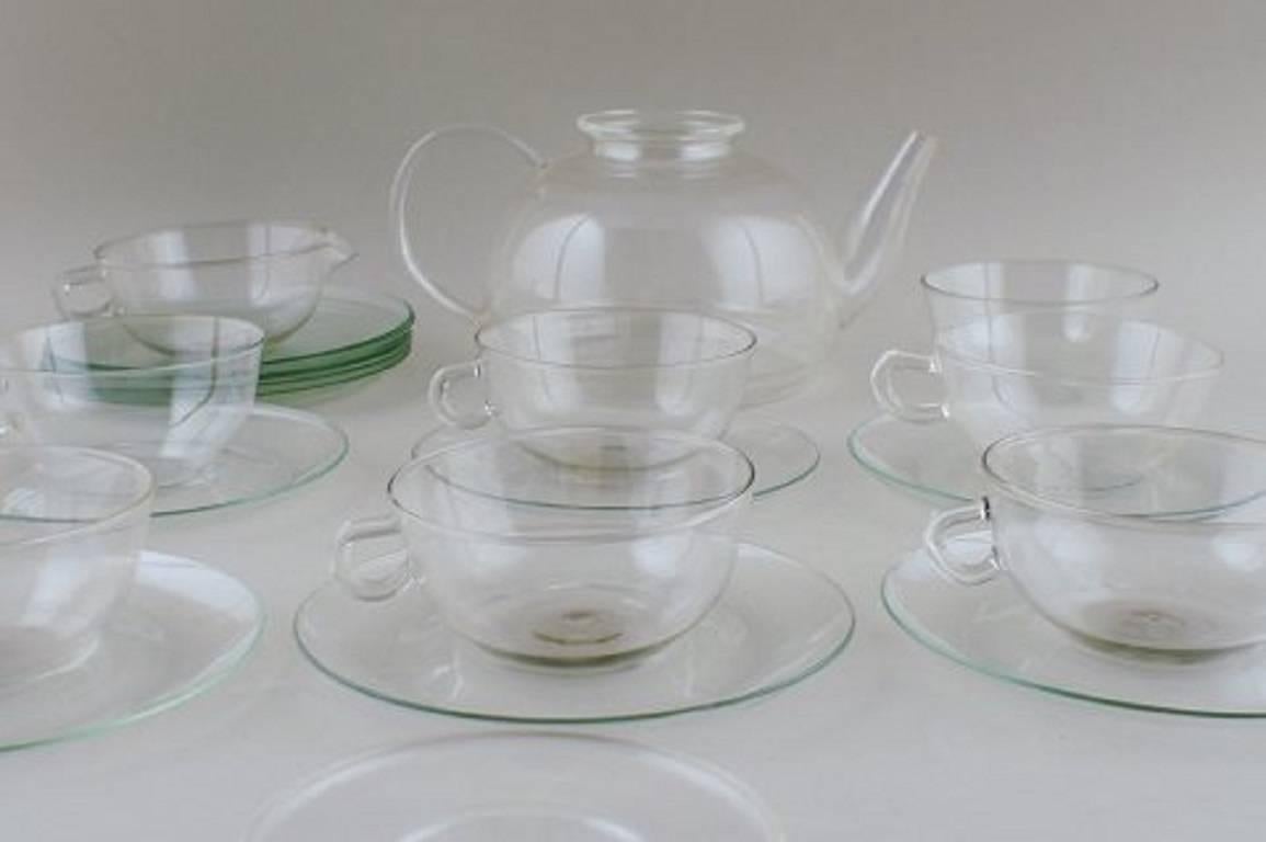 Wilhelm Wagenfeld: "Jena". 

Tea set of clear glass consisting of 1 L. teapot, six teacups with saucers, dessert plates, creamer and sugar bowl. 

Marked Jenaer glass (teapot not stamped). 

In good condition. 

Tea pot 24 cm. long and 11