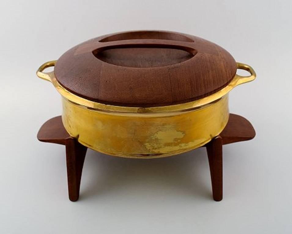 Jens H. Quistgaard: A brass pot with solid teak plinth and lid.

Stamped Dansk designs Danmark, JHQ. 

Height 17. Diameter 25 cm.

In very good condition.