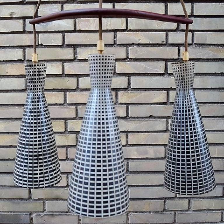 Magnificent Stilnovo style pendant light with three Diabolo shaped Murano glass shades in black with over layered white grid pattern, 

Italy, 1950s.

Excellent condition.

Measures: Height 125 cm x diameter 45 cm.