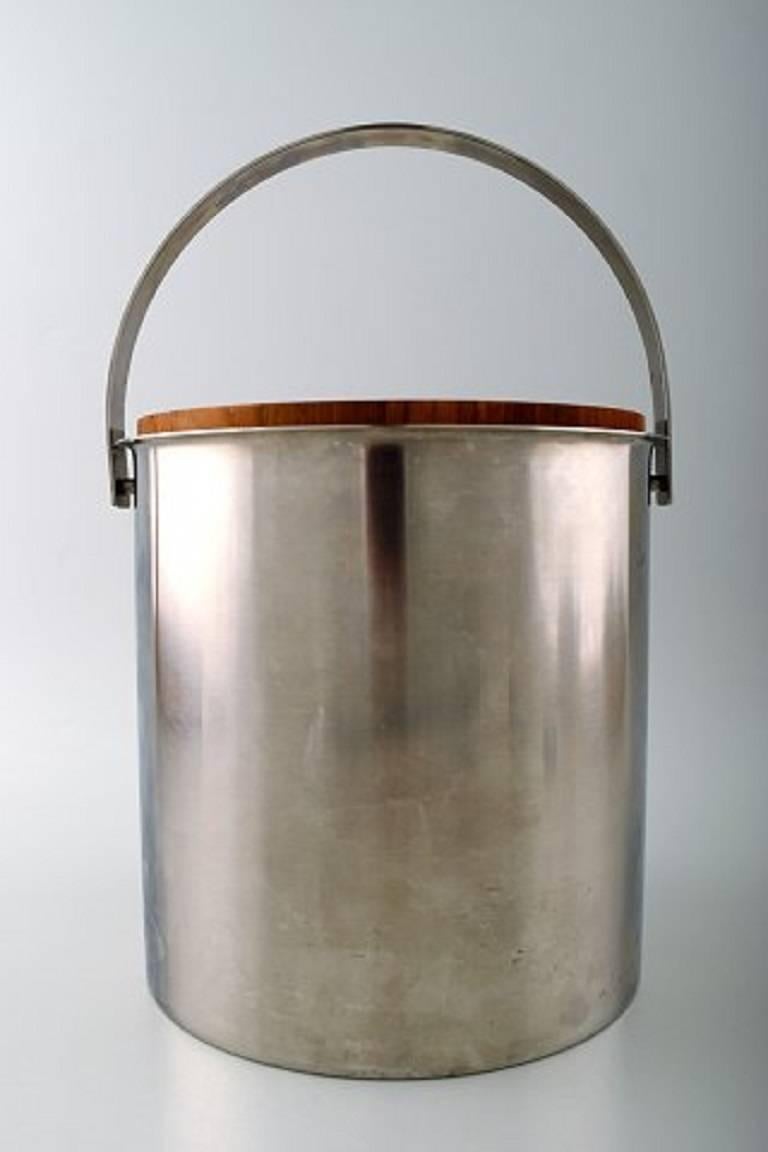 Arne Jacobsen for Stelton ice bucket stainless steel.

Lid in teak. With plastic insert.

Measures 19 cm. x 19 cm.

In perfect condition.

Marked.