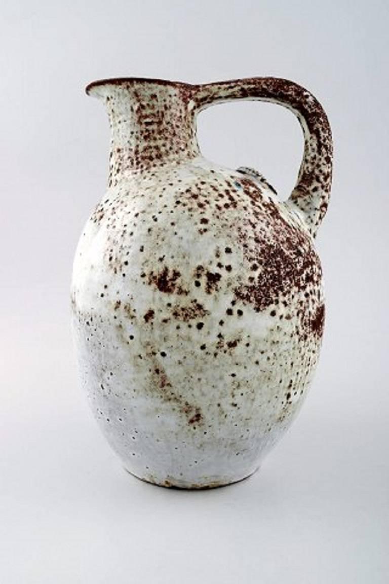 Jug of white glazed stoneware done by Gertrud Vasegaard (1913-2007), modeled with starfish on the side 1933-1935.

Signed GH (for Gertrud Hjorth, she married in 1935) and LGH for her and her sister Lisbeth Munch-Petersen's joint workshop, as they