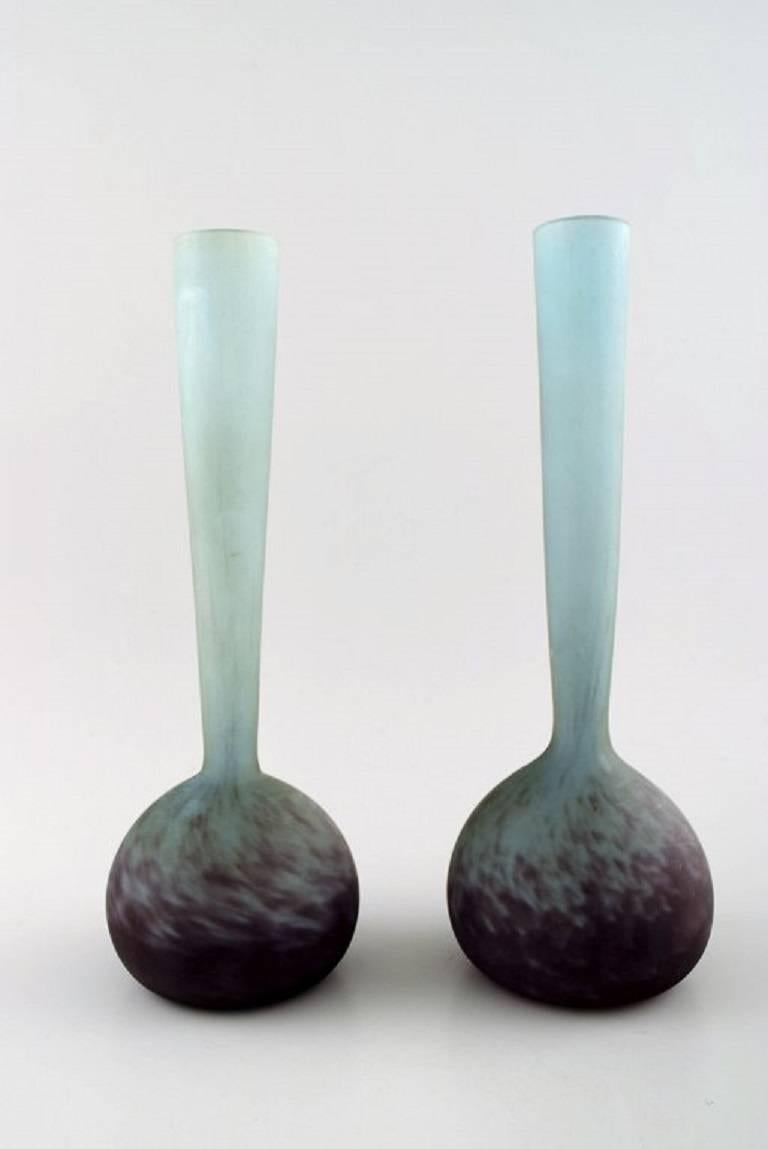 André Delatte For Daum, Nancy. A Pair Of Soliflore Art Glass Vases In Blue And Violette Nuances.

France, circa 1940s.

Signed.

27 CM. High. 11 cm. in diameter.

In perfect condition.