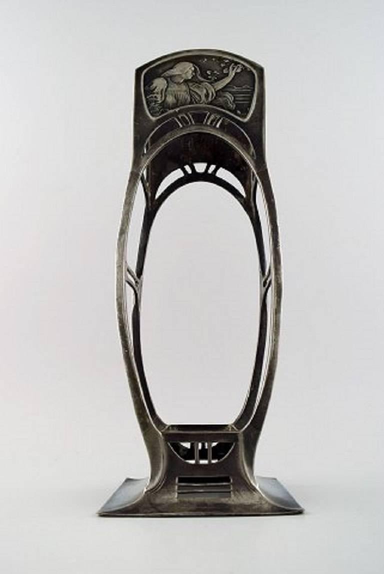 Vaso Art Nouveau, WMF (Württembergische Metallwarenfabrik).

Buone condizioni. Manca l'inserto in vetro.

Misure: 34,5 cm. X 10 cm.

Timbrato.