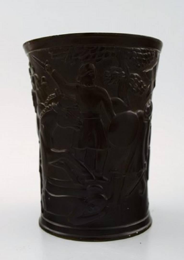 Cup or vase, designed by Just Andersen.

Decorated with the legend of Dannebrog (The Danish flag), where Dannebrog felt down from heaven on June 15, 1219 at the Battle of Lyndanisse in Estonia.

Designed in "disko metal" and signed 'Just