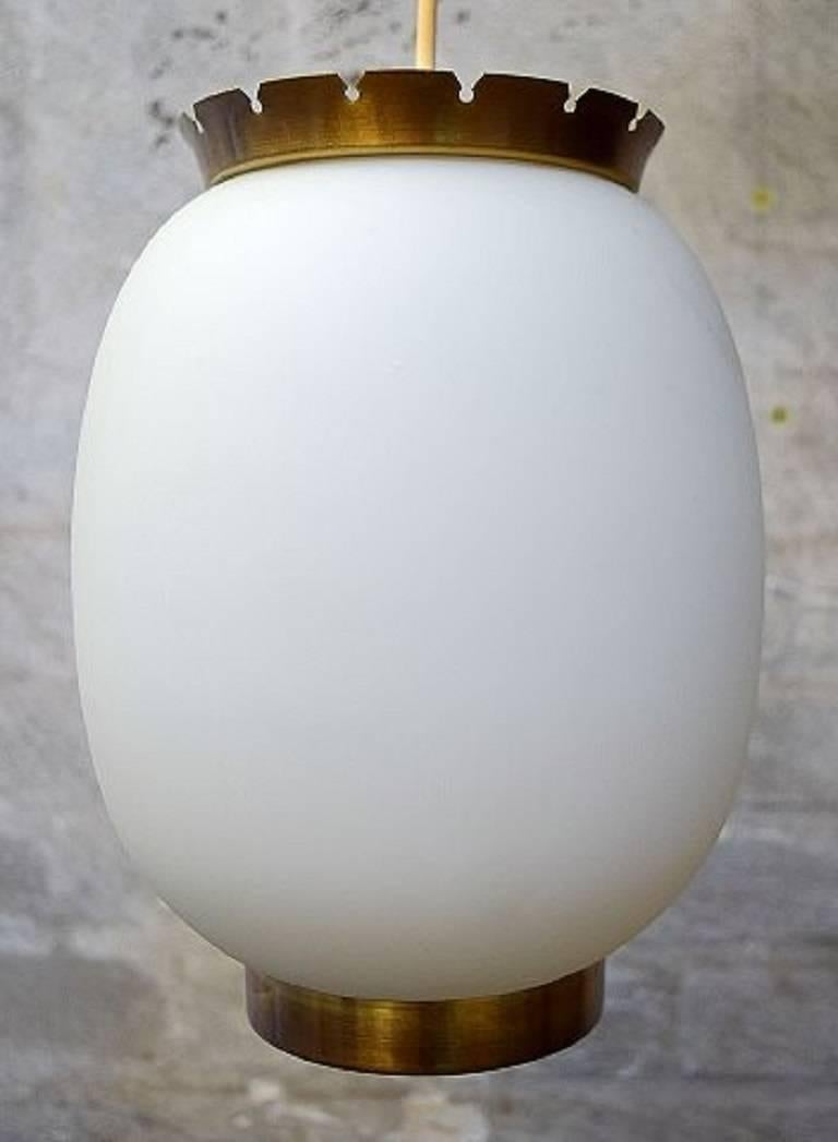 Bent Karlby "China Lamp".

A pair of pendants of matte opal glass with brass fittings.

Danish design mid-20th century.

Produced by Lyfa in the 1950s.

Measures: Height including mountings 23 cm. Diameter 17 cm.

In good