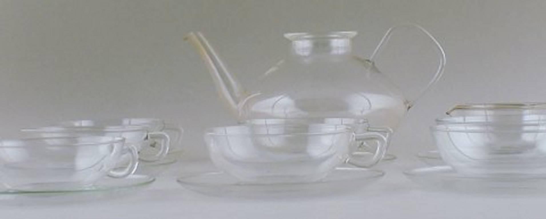 Wilhelm Wagenfeld: "Jena". Tea set in clear glass consisting of 1 L. teapot, seven teacups with saucers and creamer. 

Marked Jenaer glass. 

In good condition. 

Tea pot 24 cm. long and 13 cm tall.