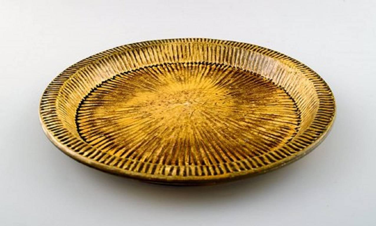Kähler, Denmark, glazed dish, 1930s.
Designed by Svend Hammershøi.
Uranium yellow glaze.
Measures 24.5 x 2.5 cm.
Stamped.
In perfect condition.