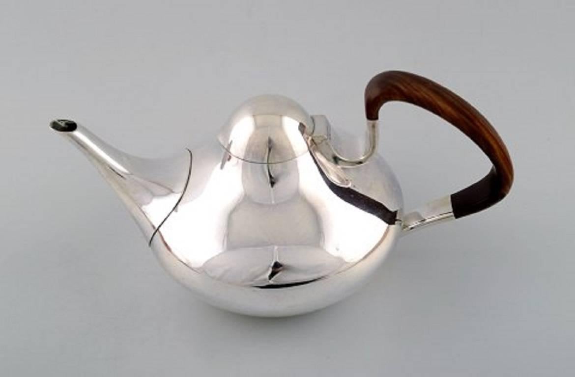 Georg Jensen, tea pot in sterling silver # 1017.
With handles in guayacan tree.
Drawn by Henning Koppel (1918-1981) in 1956.
Measures: 25 cm long including handle x 12.5 cm high.
Stamped with post 1945 stamps.
In perfect condition.