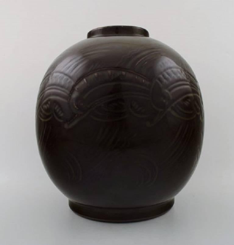 Nils Thorsson for Royal Copenhagen. Large jar in stoneware, motifs in the form of sea plants and fish, Mid-20th century.
Decorated with beautiful olive glaze.
Signed 2920 and 529, three blue waves for Royal Copenhagen.
Measures: Height 24.5